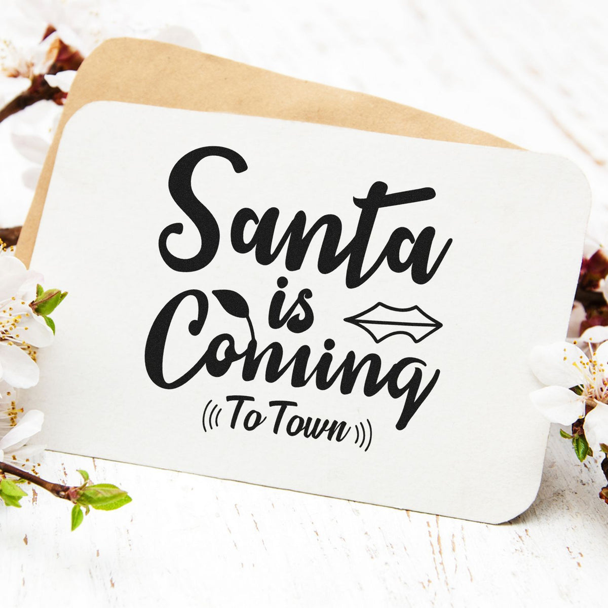 Black Santa is Coming to Town stamp on white card with beige backing and floral accents.