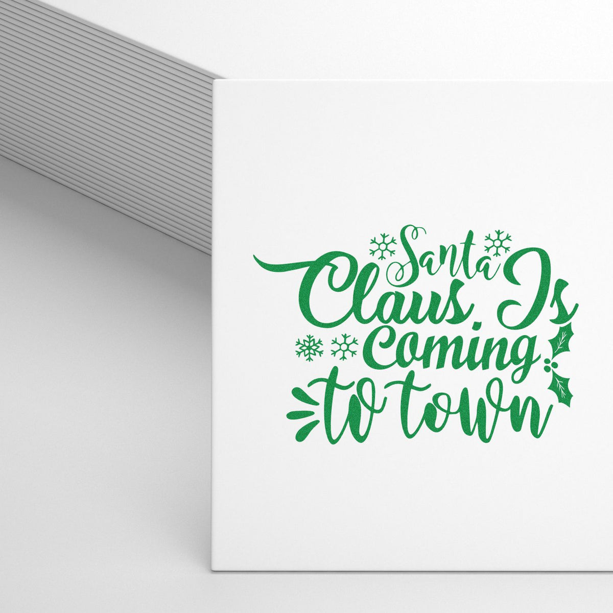 Green Santa Claus Is Coming to Town holiday stamp and seal design with snowflakes and holly on white.