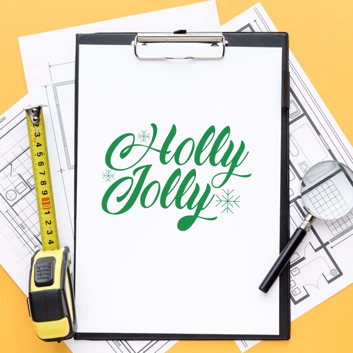 Green Holly Jolly custom stamp and seal on clipboard, with tape measure, magnifying glass, and blueprint papers on yellow background.