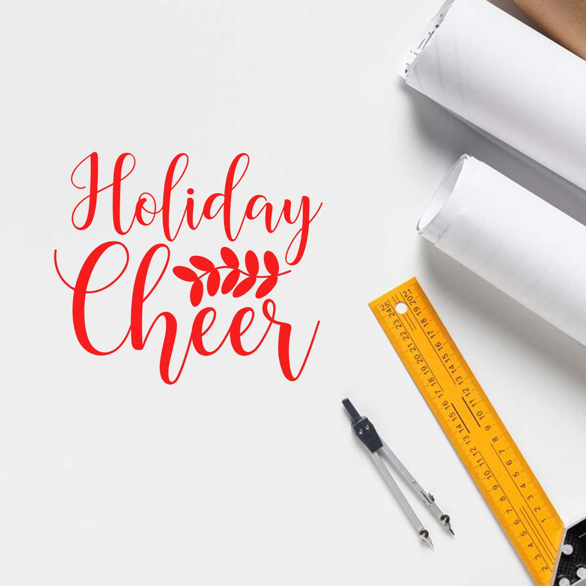 Red Holiday Cheer stamp and seal design with leaf motif, white boxes, yellow ruler, and compass on white background.