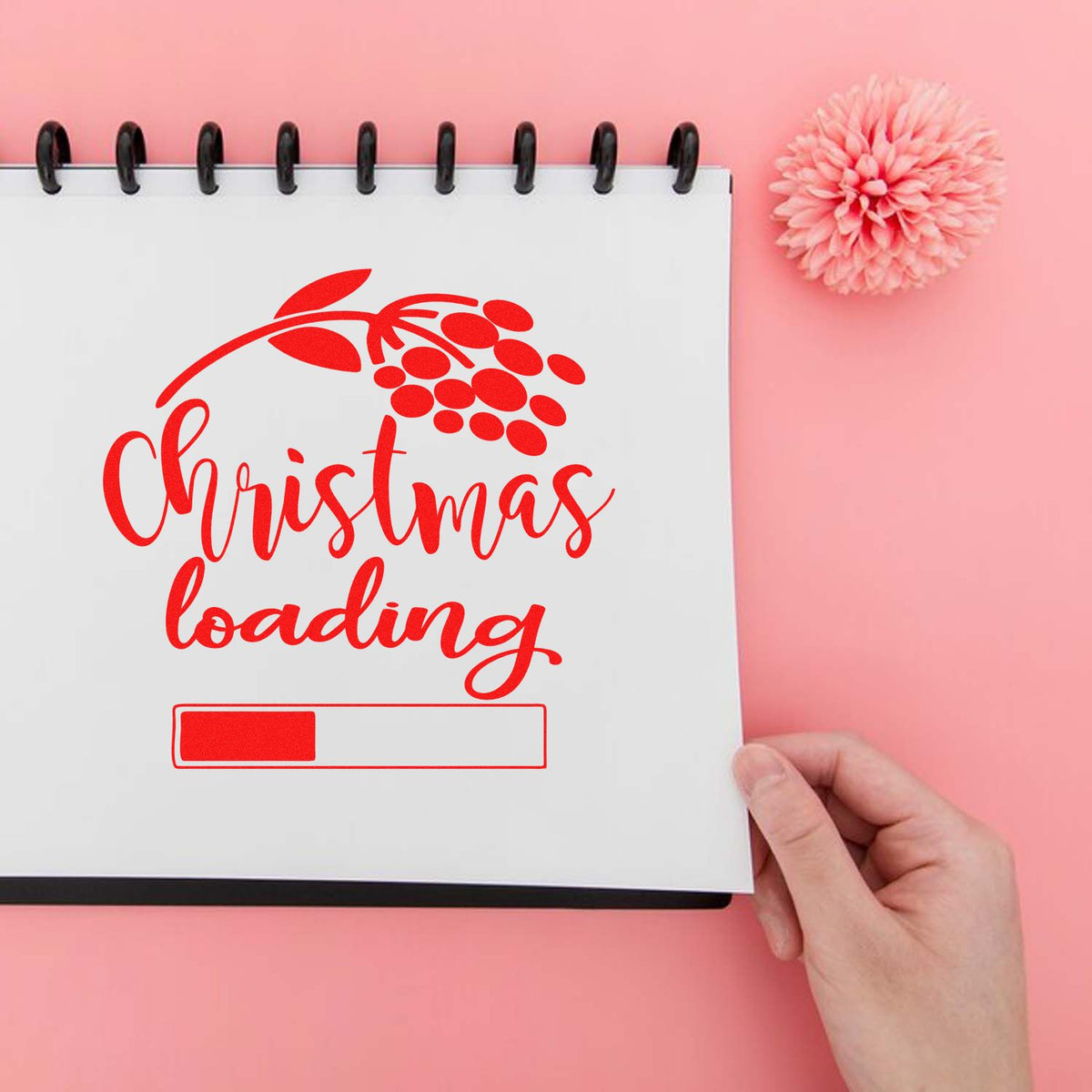 Red Christmas loading stamp and seal on a white notebook page, with progress bar and pink background.
