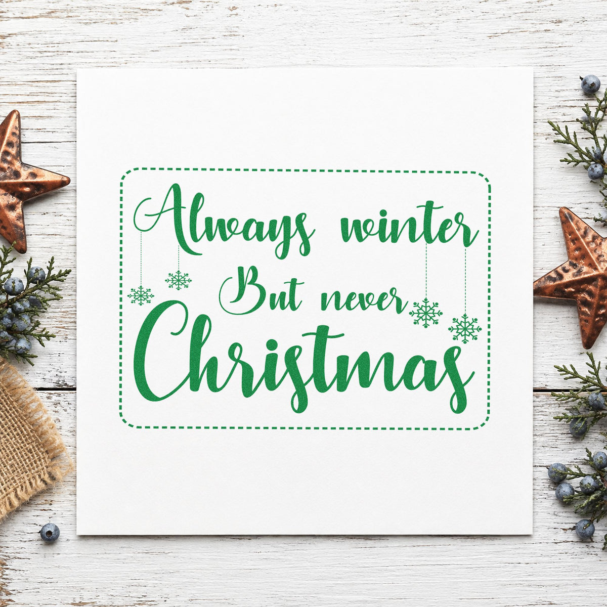 Always Winter Never Christmas craft stamp imprint in green ink on a handmade project, one idea being novel gift tags.