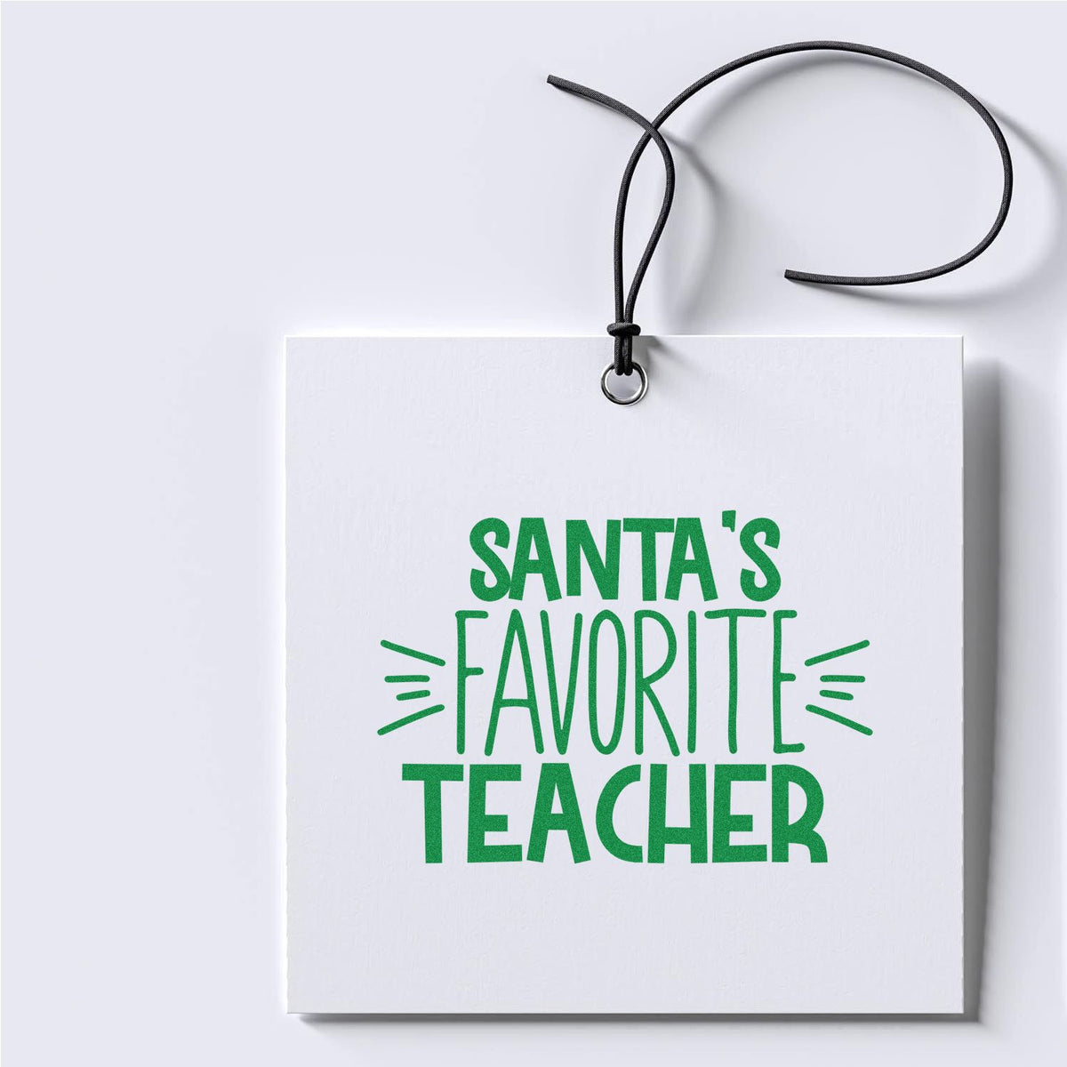 White hanging gift tag seal with black cord and green Santas Favorite Teacher lettering.