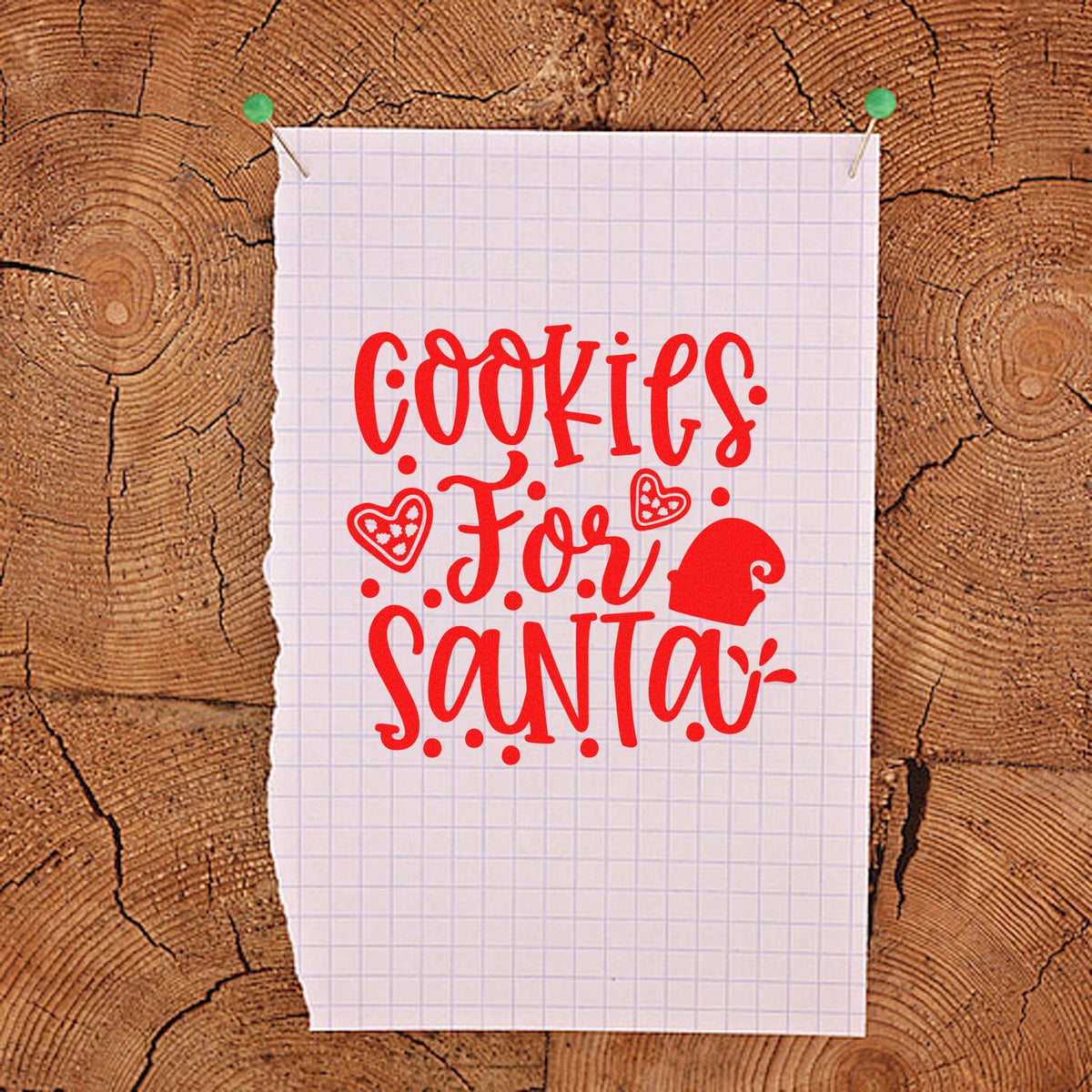 Red Cookies for Santa stamp design with hearts and Santa hat on pinned graph paper over rustic wood.