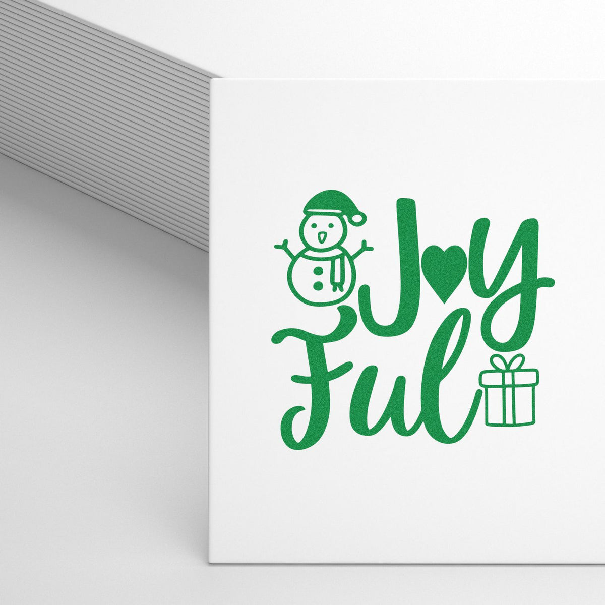 Green holiday stamp and seal design reading Joyful with snowman and gift on a white card.