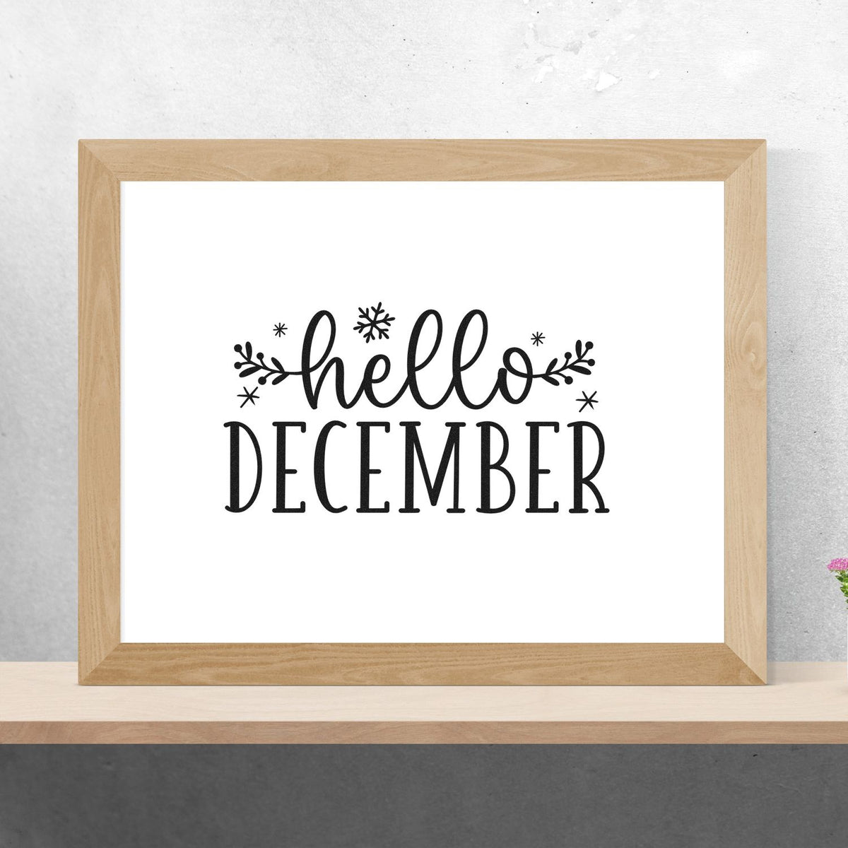 Wooden-framed stamp design with black hello December lettering, snowflakes, and leafy accents on a white background.