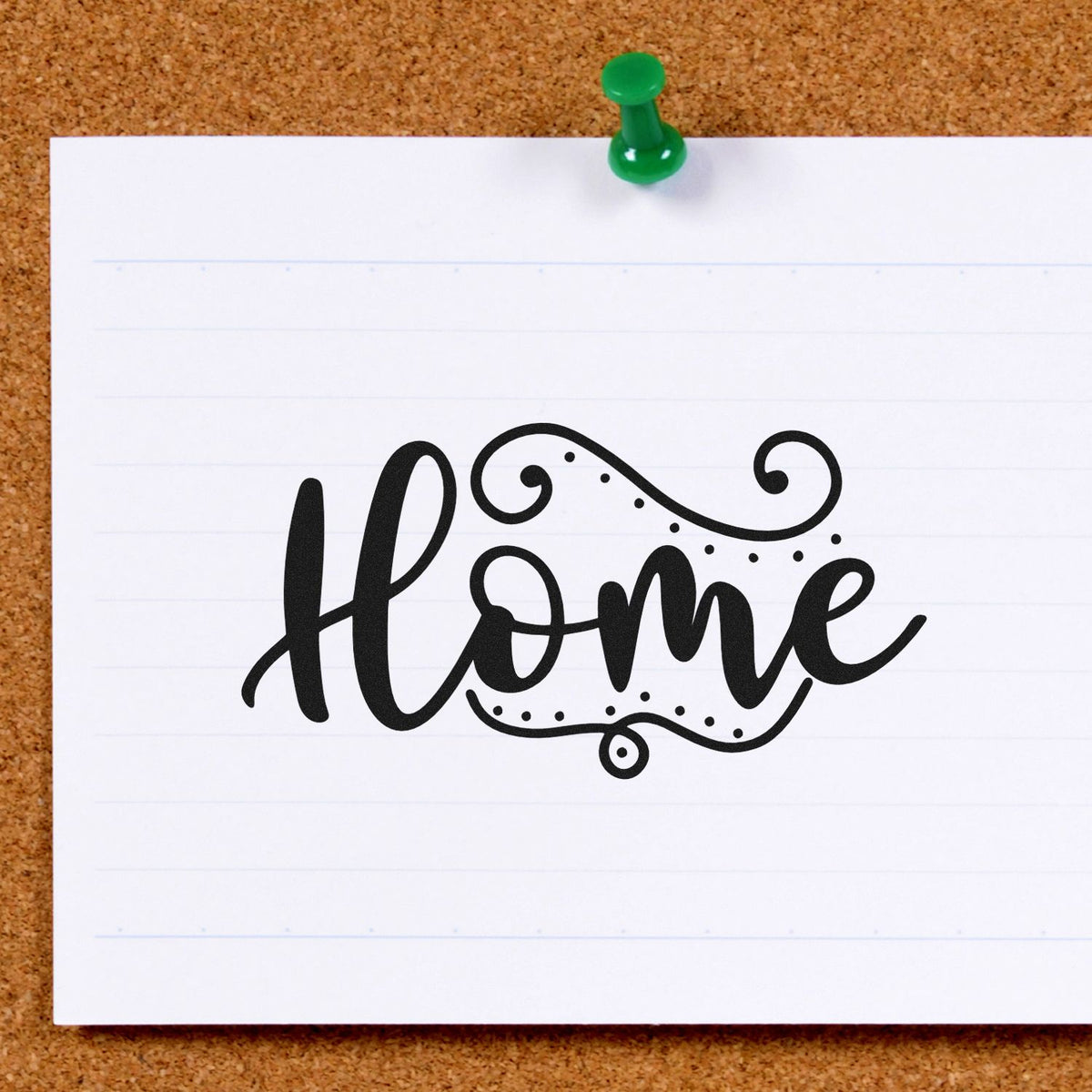 Black decorative Home stamp and seal on white lined paper, pinned to a corkboard with a green pushpin.