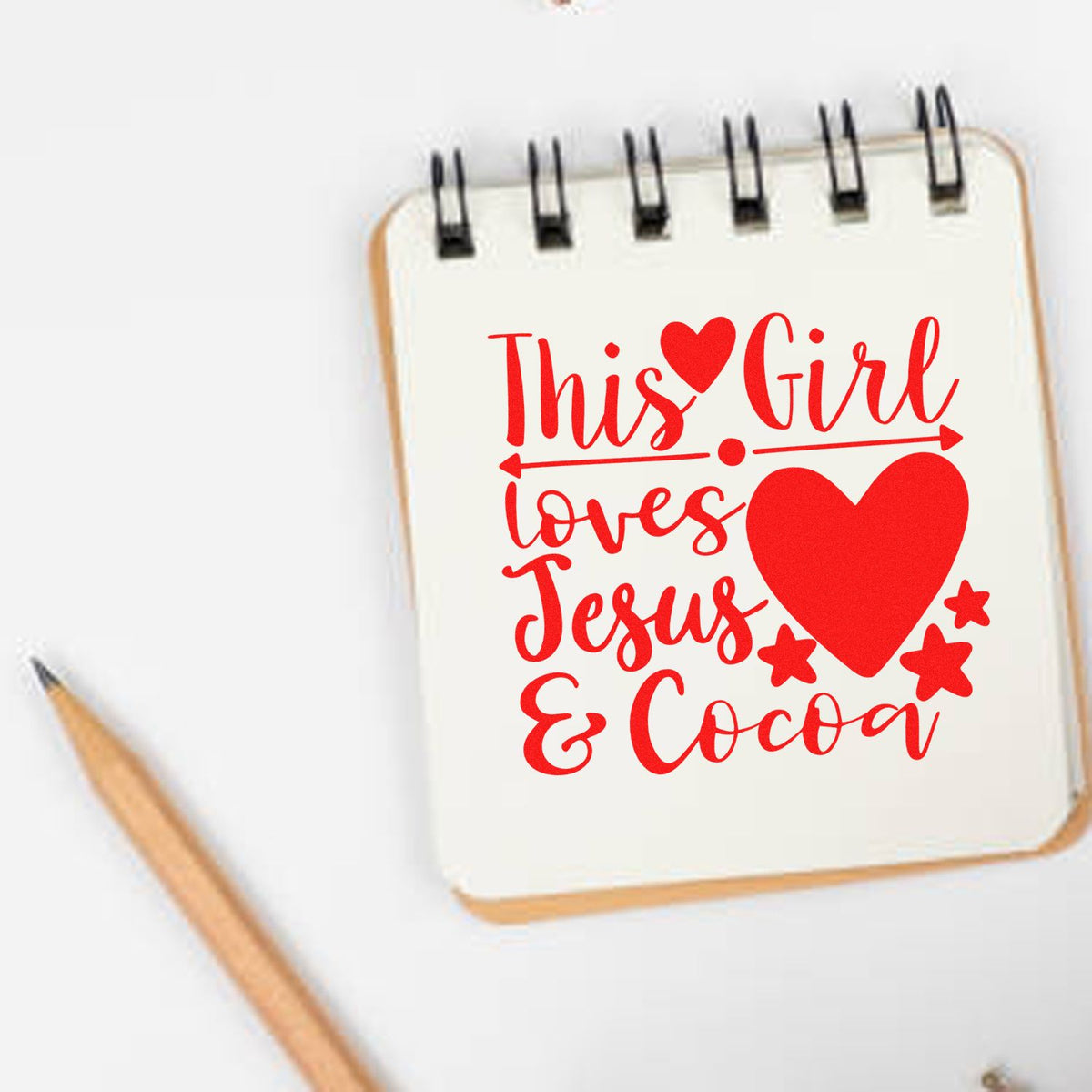 Red custom stamp design on notebook reading This Girl loves Jesus & Cocoa with heart and stars.