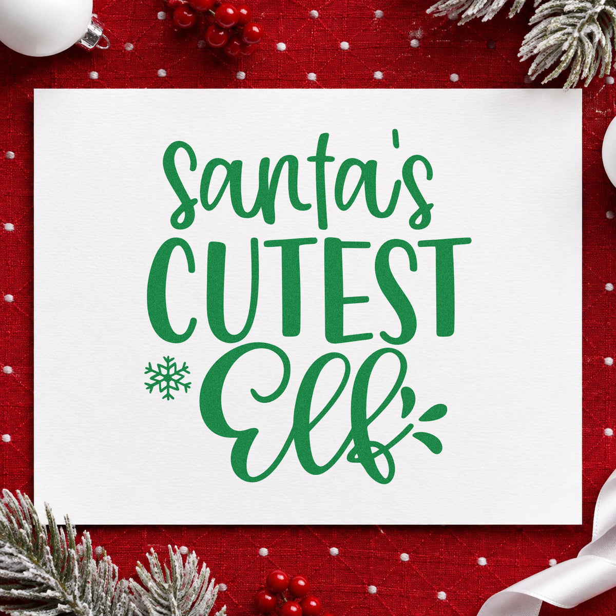 Santa's Cutest Elf Lettering craft stamp imprint in green ink on a handmade project, one idea being onesie stamping.