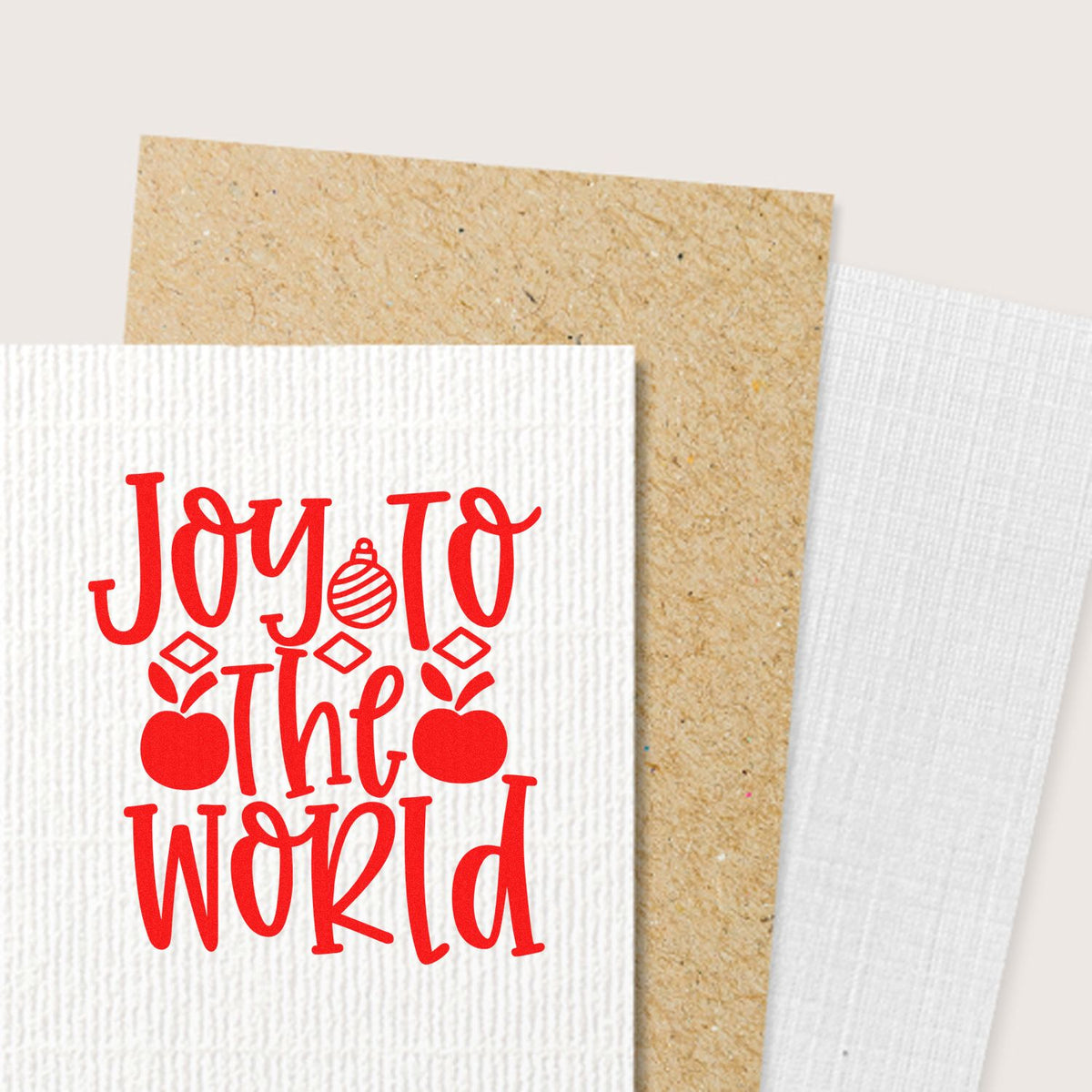 Red Joy to the World holiday stamp on textured white cardstock, layered with kraft and white seal papers.