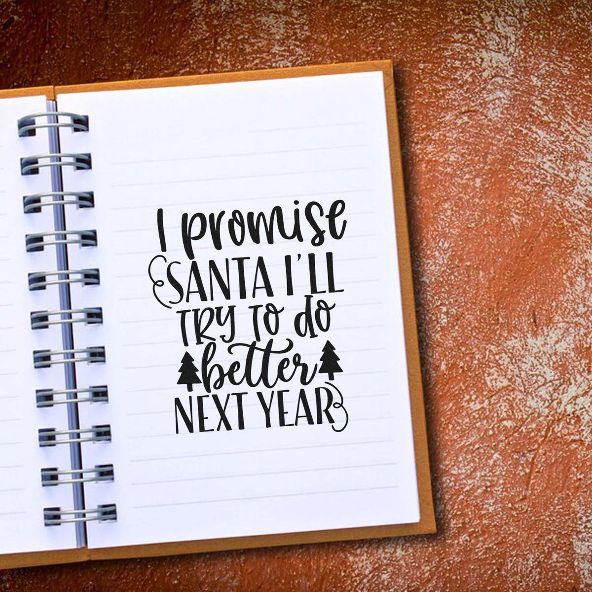Black holiday stamp on a white lined notebook page, reading I promise Santa Ill try to do better next year, with tree icons.