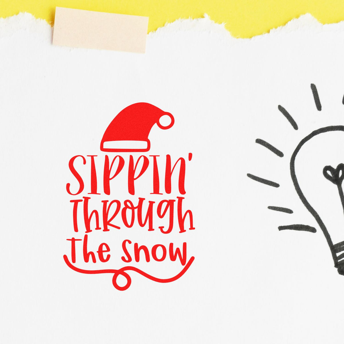 Red holiday stamp and seal with Santa hat reading Sippin Through The Snow on white paper, yellow tape and black lightbulb.