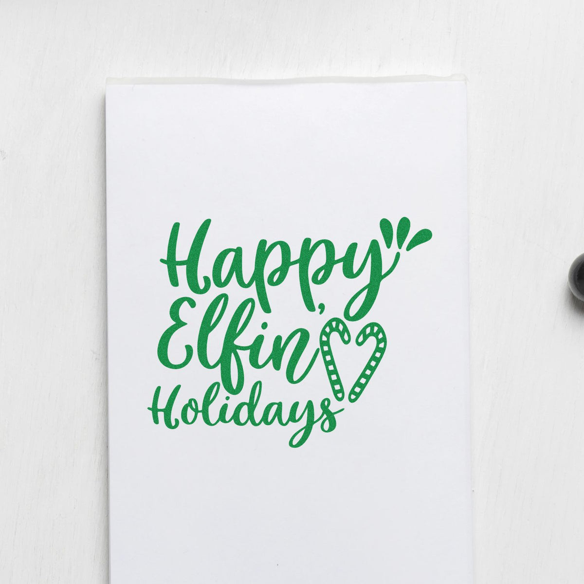 Green Happy Elfin Holidays stamp seal design on white paper with candy cane heart accents