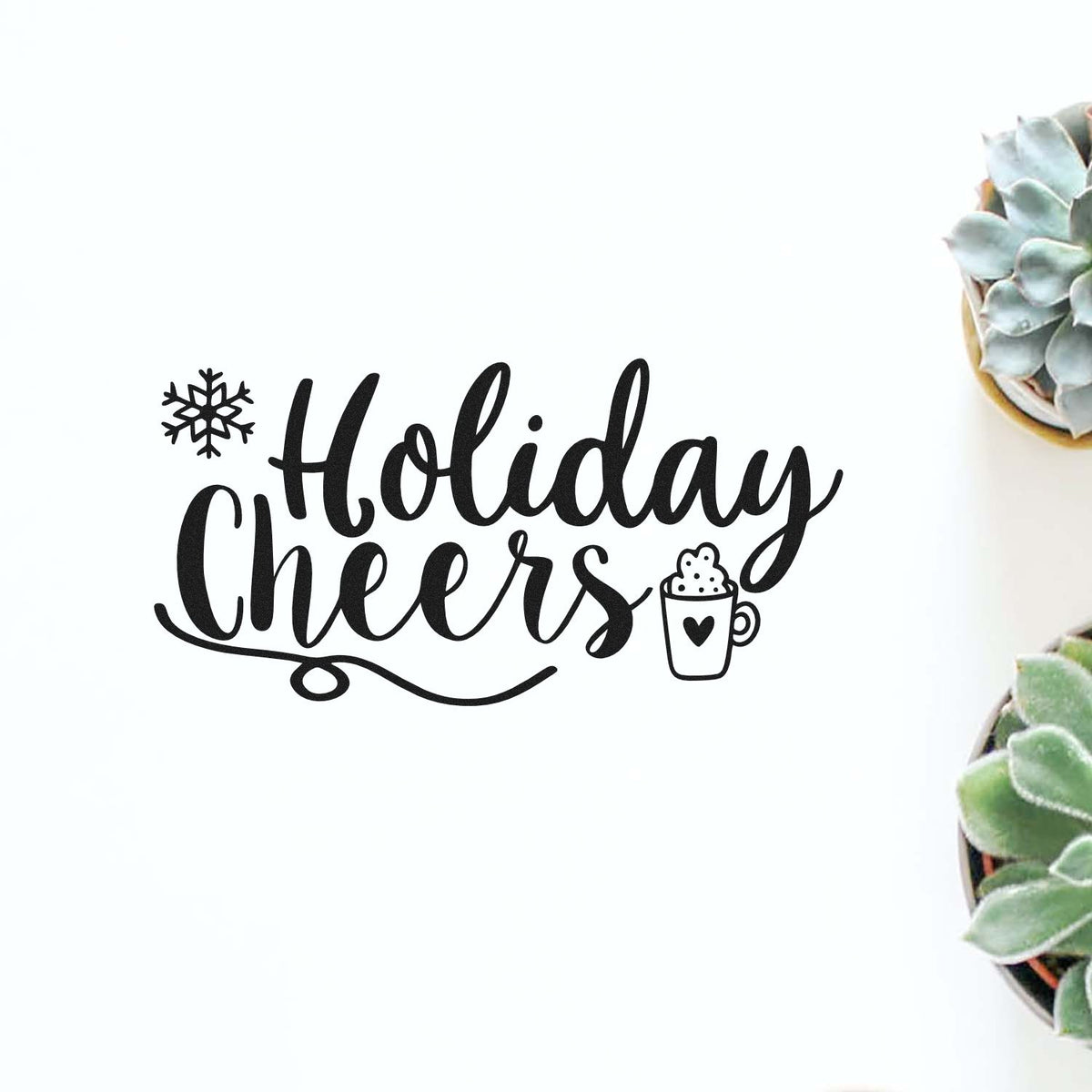 Black Holiday Cheers stamp and seal with snowflake and mug icon on white, beside green succulents