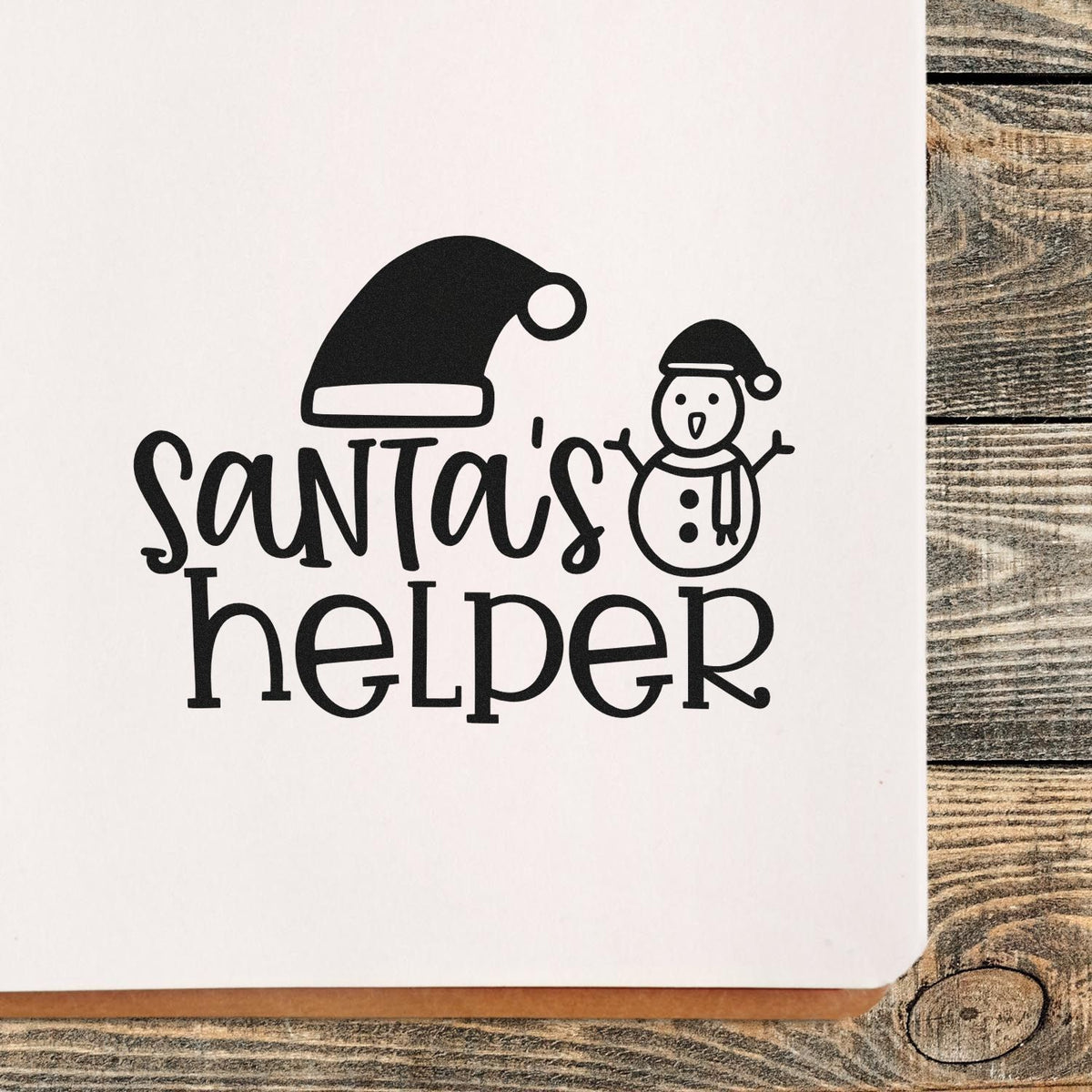 Black Santas helper custom stamp and seal design with Santa hat and snowman on white paper