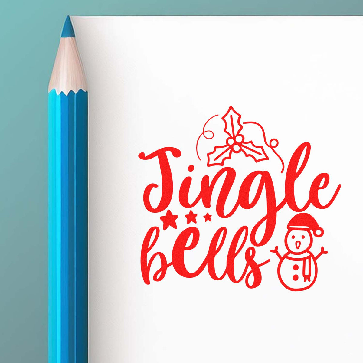 Red Jingle Bells stamp and seal design with holly and snowman on white paper beside a blue pencil.