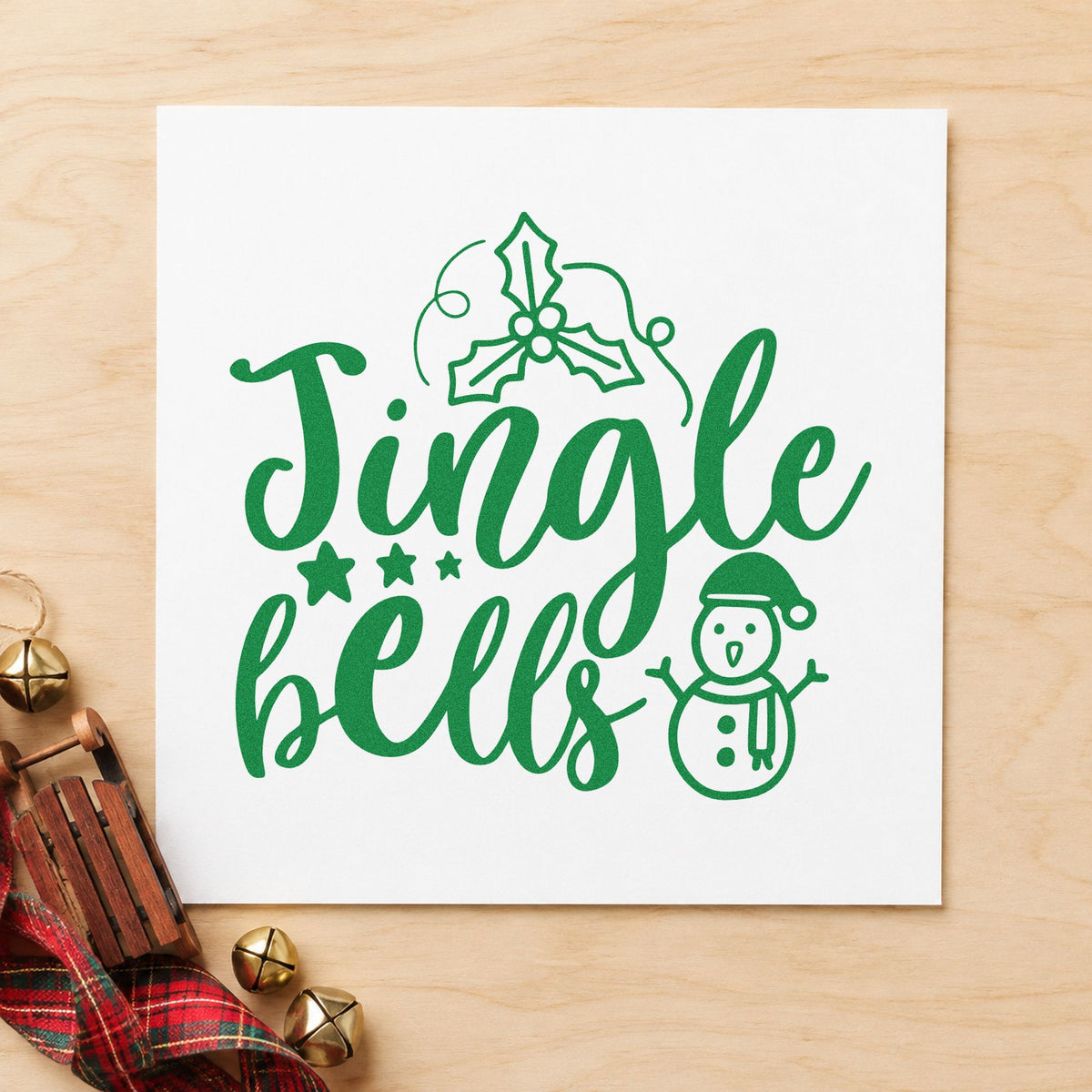 Jingle Bells Holly Snowman craft stamp imprint in green ink on a handmade project, one idea being songsheet clip tags.