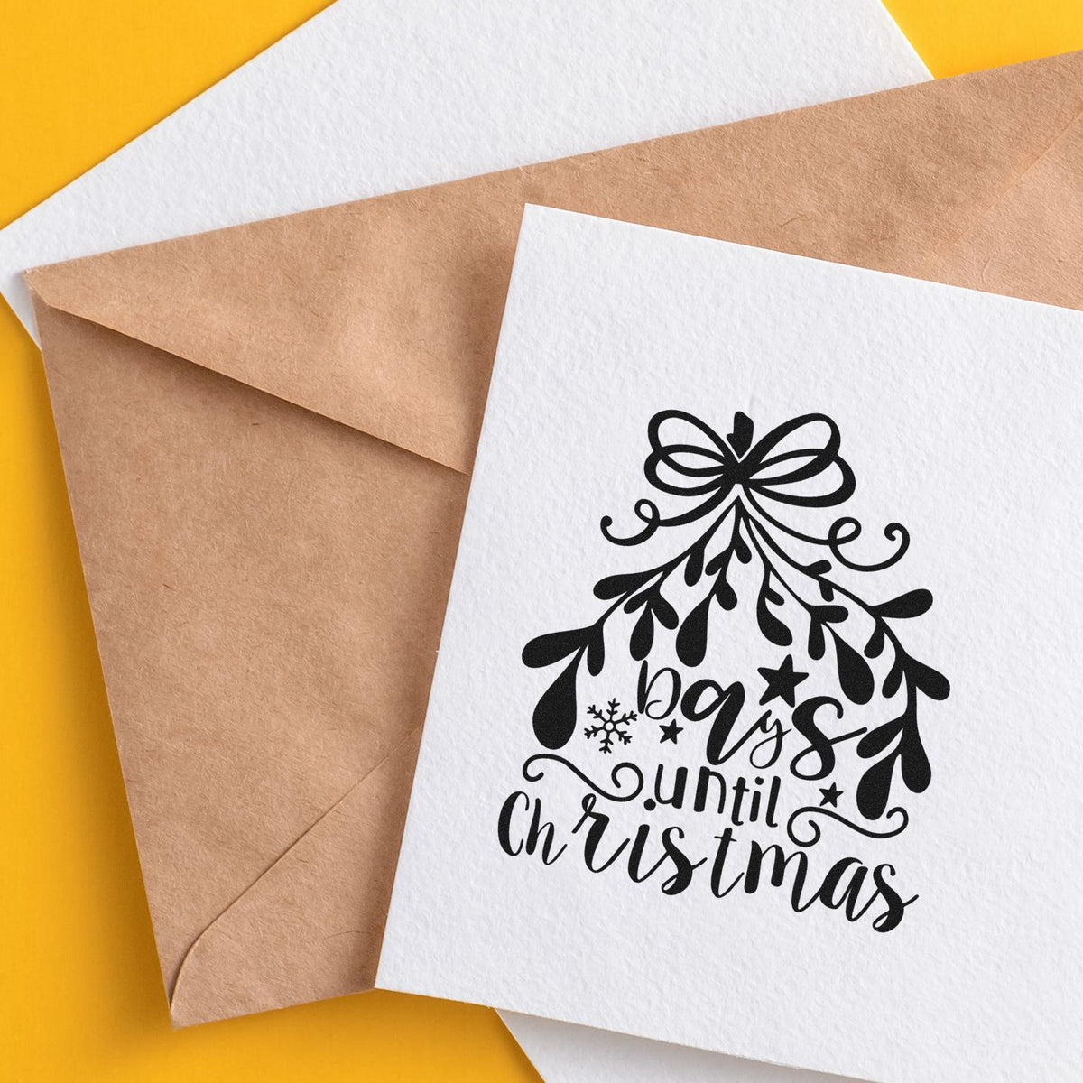 Holiday stamp and seal design on white card, black bow-and-branches tree with days until Christmas, over kraft envelopes on yellow.