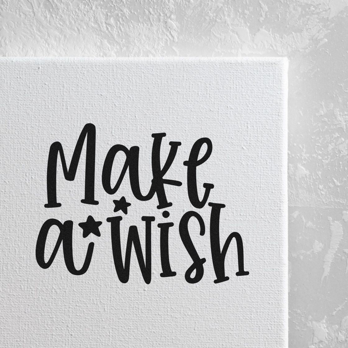 Black Make a Wish stamp and seal design with stars on a textured white background.