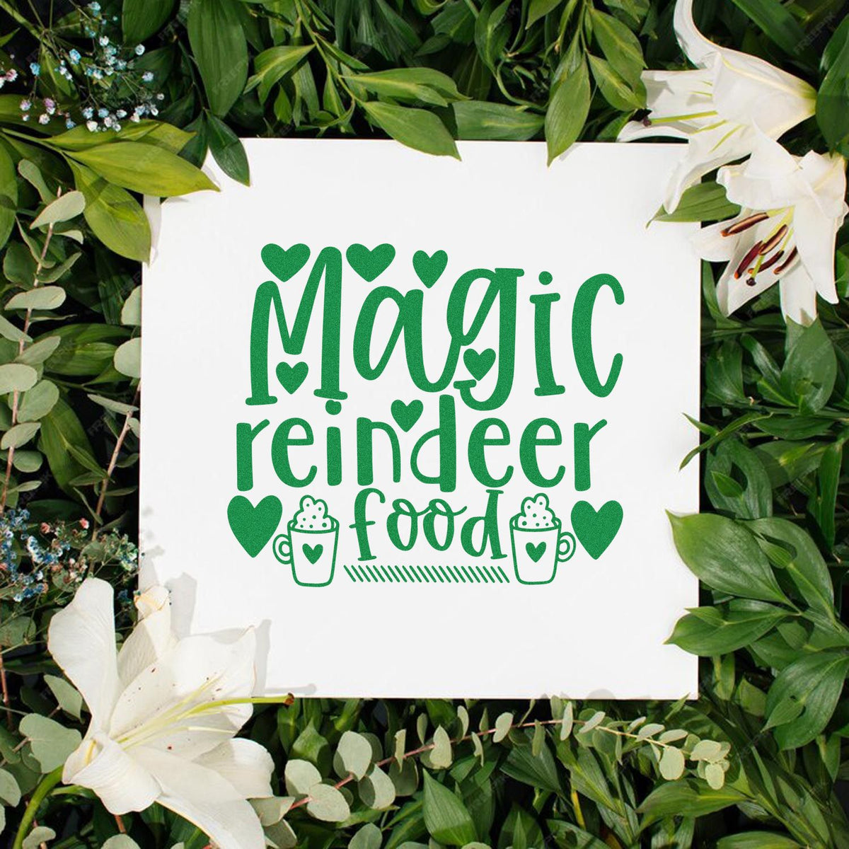 Green custom stamp and seal reading Magic reindeer food, with hearts, mugs, and white lilies on a leafy background.