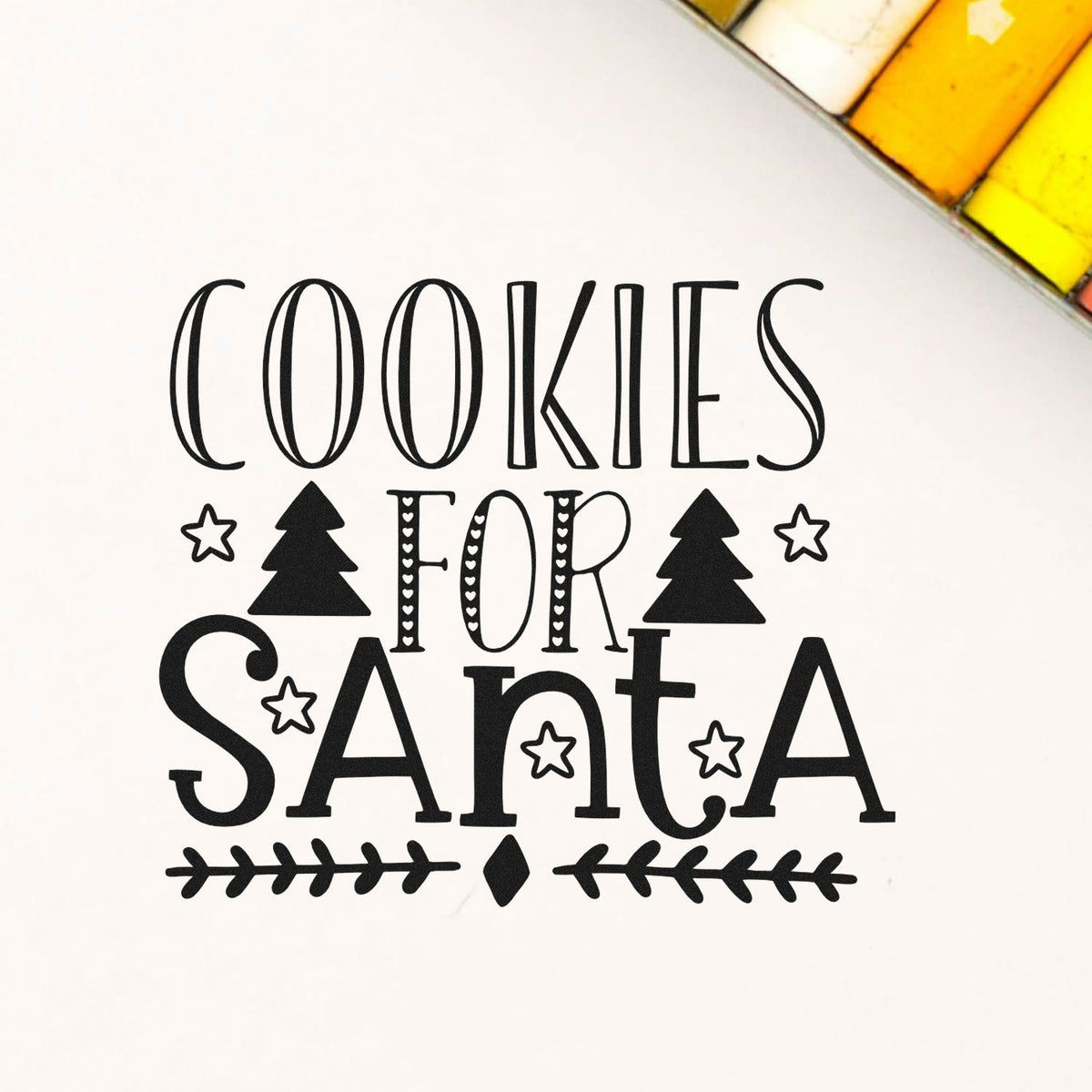 Black holiday stamp and seal design reading Cookies for Santa with stars and trees on a white background.