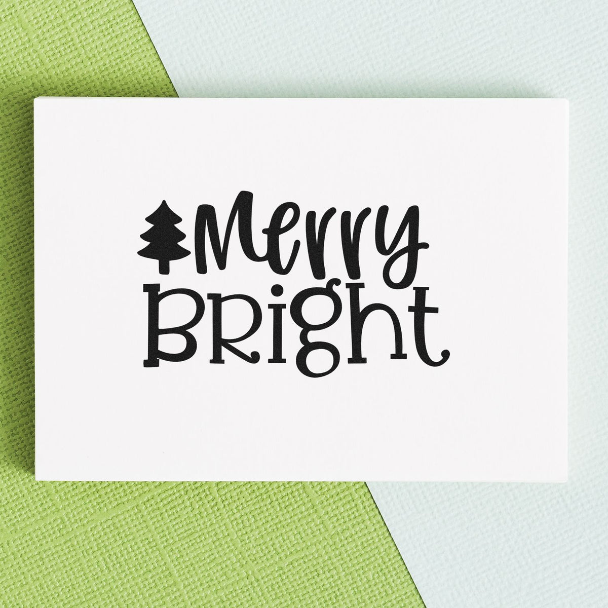 Black Merry Bright holiday stamp and seal with tree icon on white card over green and white textured background.