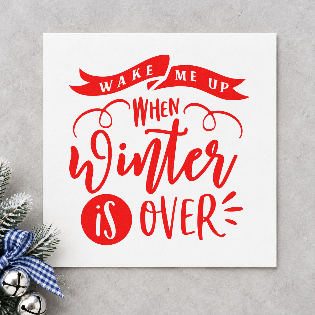 Wake Me When Winter Ends rubber stamp shown in red ink, stamped for projects such as suitcase bag labels.