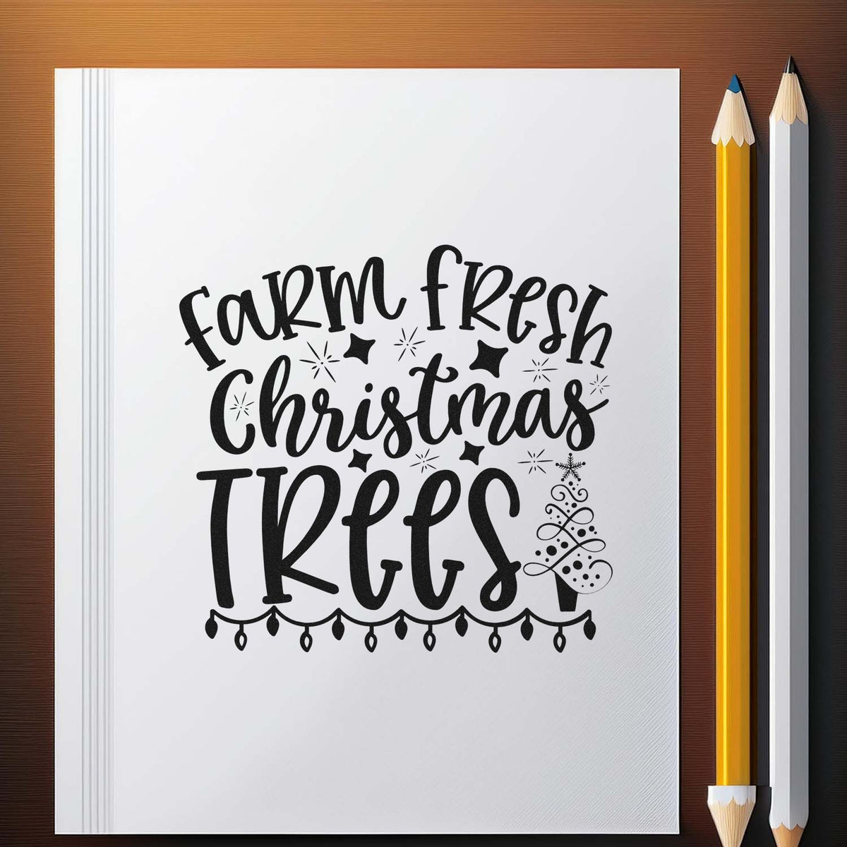 Black farm fresh Christmas trees stamp and seal design on white sheet with stars ornaments and string lights beside yellow and white pencils