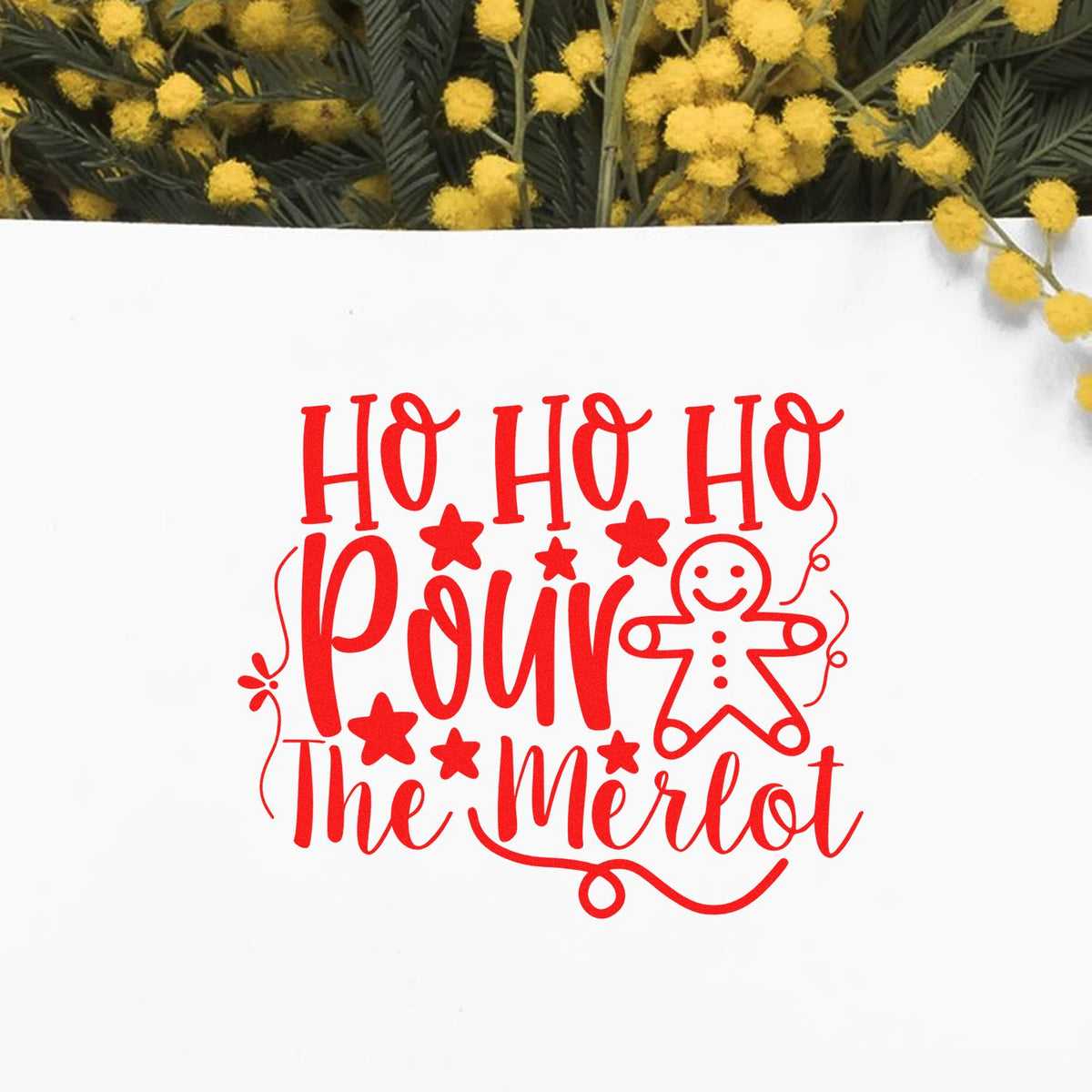 Red holiday stamp and seal design reading Ho Ho Ho Pour The Merlot with gingerbread man on white, framed by yellow blooms.