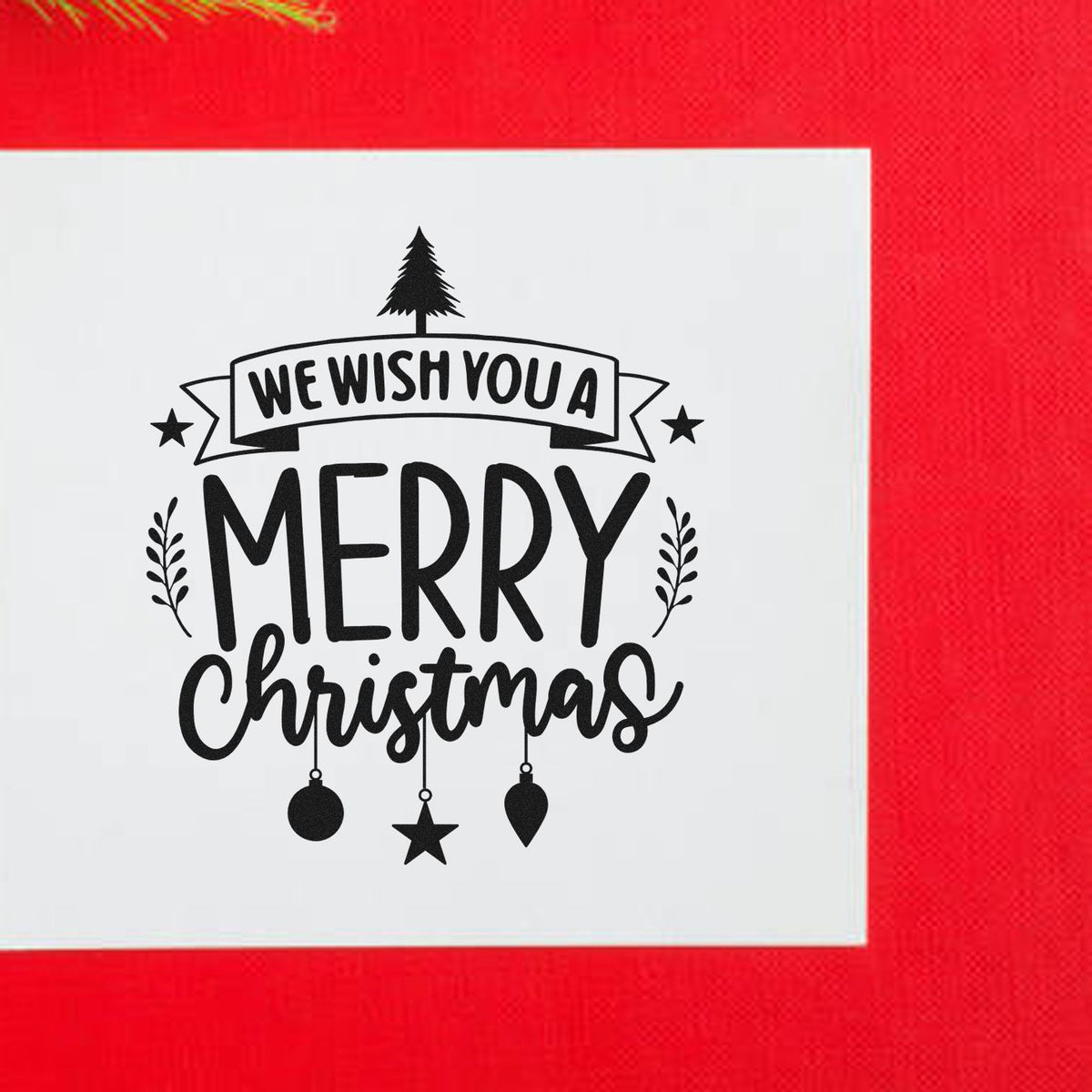 Black We wish you a Merry Christmas stamp and seal on white card, with tree, stars and ornaments on a red background.
