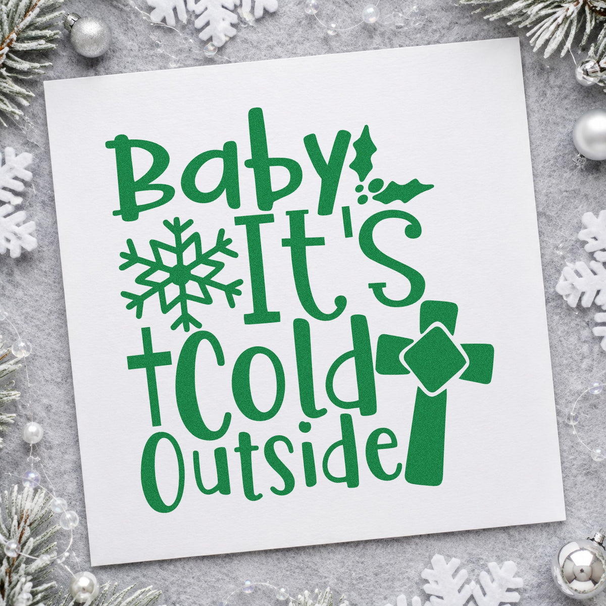 Baby It's Cold Outside Cross craft stamp imprint in green ink on a handmade project, one idea being coat drive tags.