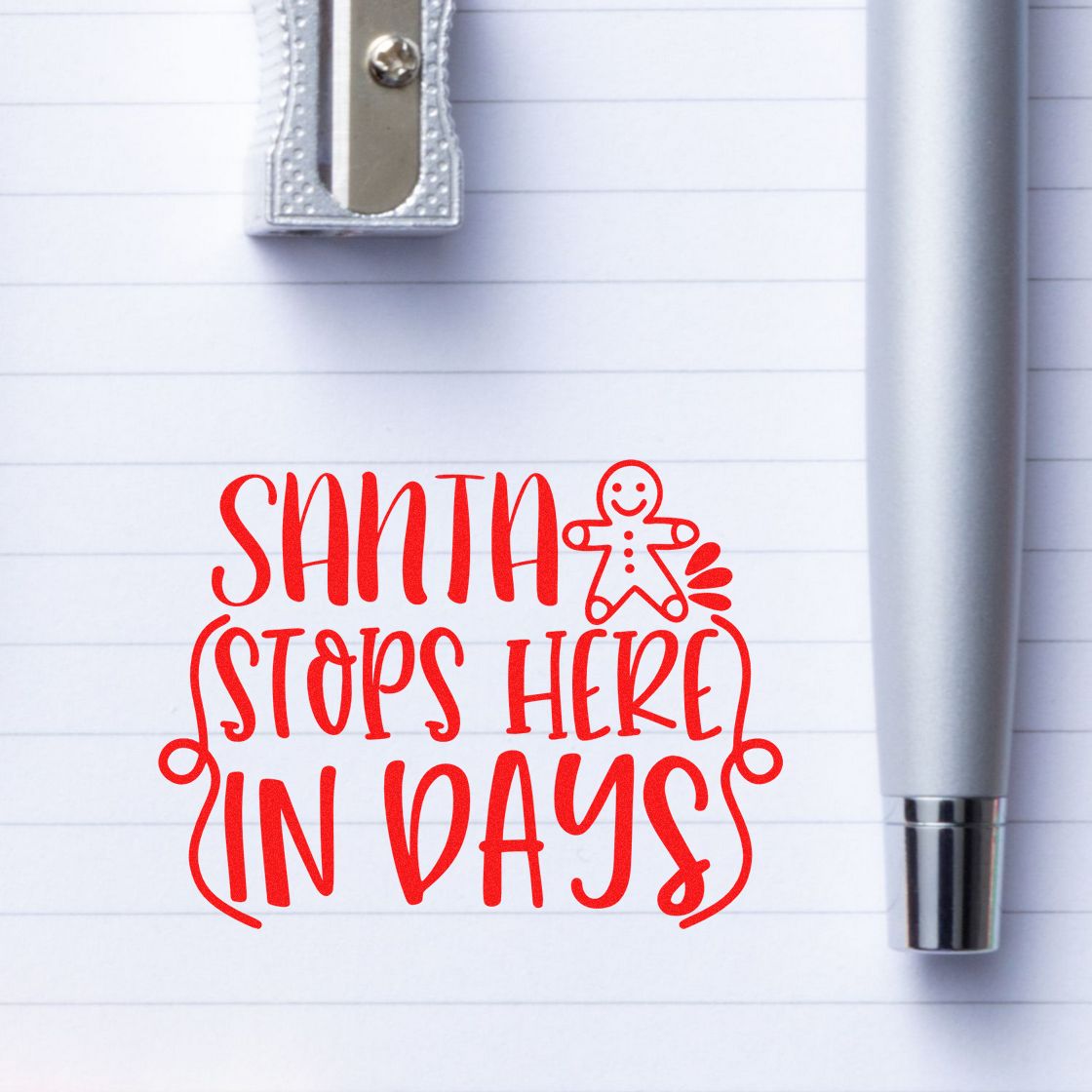 Red Santa Stops Here in Days stamp with gingerbread figure and silver seal tool on lined paper.