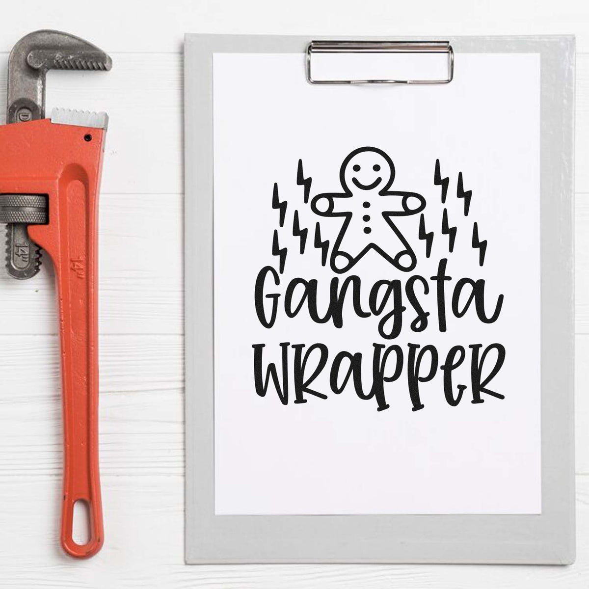 Orange pipe wrench beside clipboard seal design with black gingerbread figure, lightning bolts, and Gangsta Wrapper text.
