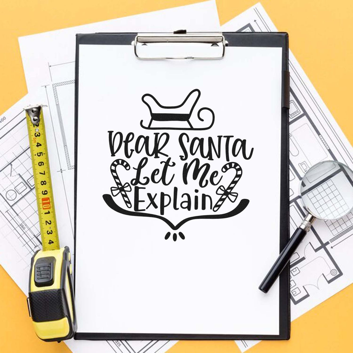 Black Dear Santa Let Me Explain stamp and seal design on clipboard, with tape measure, blueprints, and yellow background.