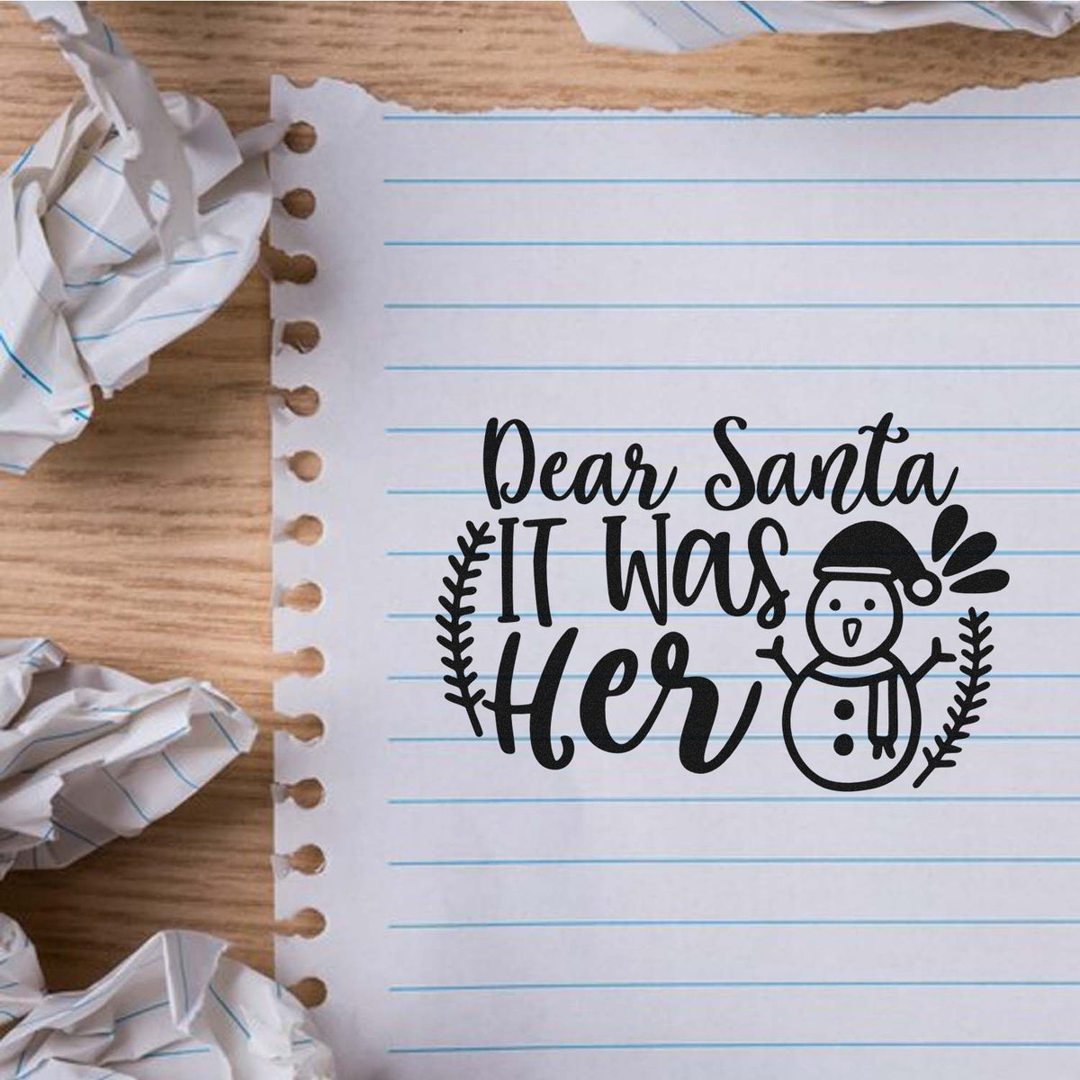 Black Christmas stamp and seal with Dear Santa It Was Her, snowman, and wreath on lined notebook paper.