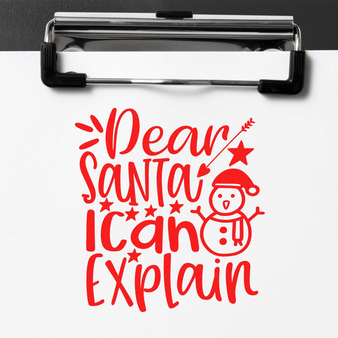 Red holiday stamp and seal design reading "Dear Santa I can Explain" with a snowman on white paper clipped to a clipboard.