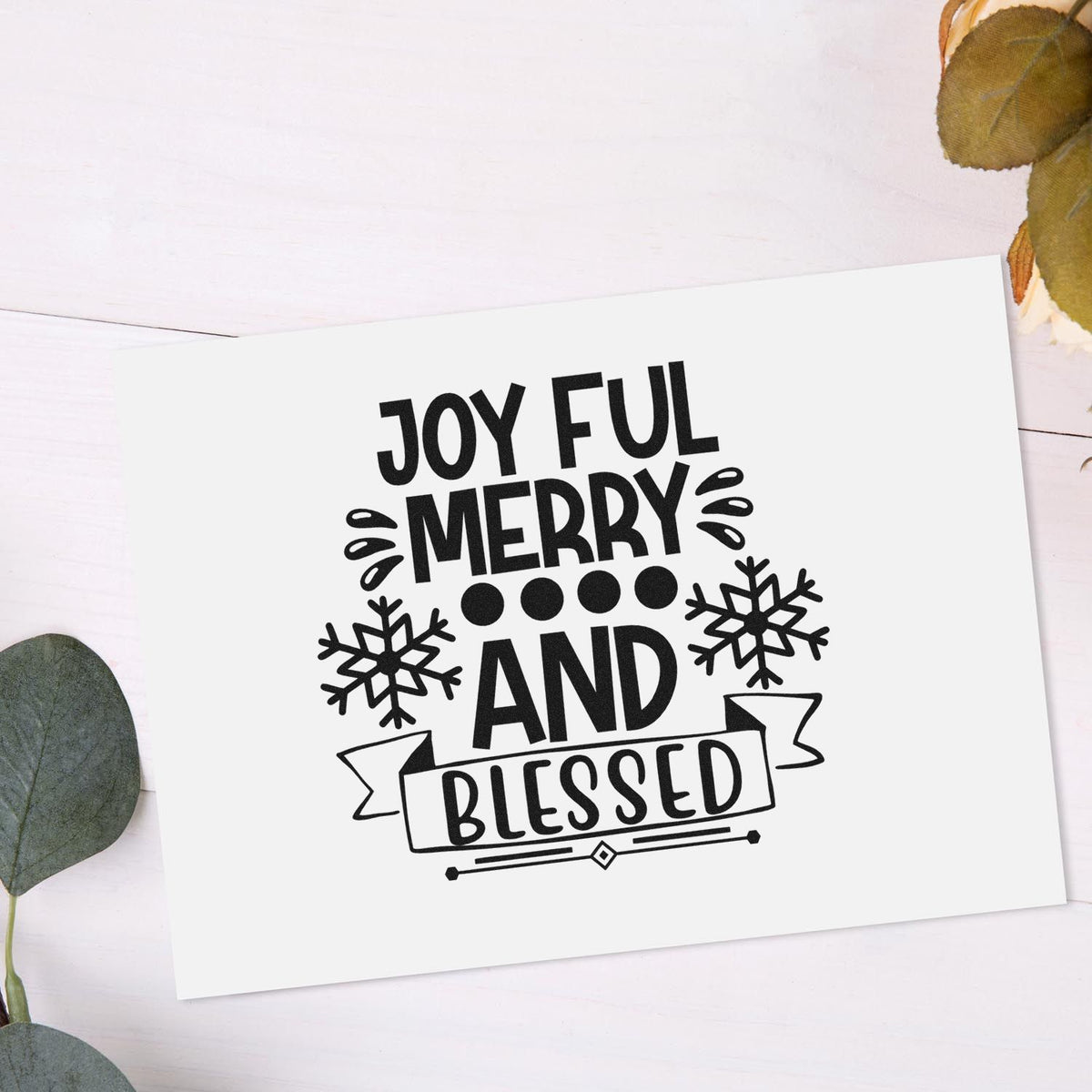 Black holiday stamp and seal design reading Joyful Merry and Blessed with snowflakes on a white card.