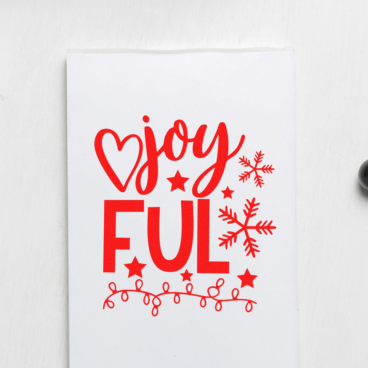 Red holiday stamp and seal design with joy ful, heart, snowflakes, stars, and string lights on a white background.