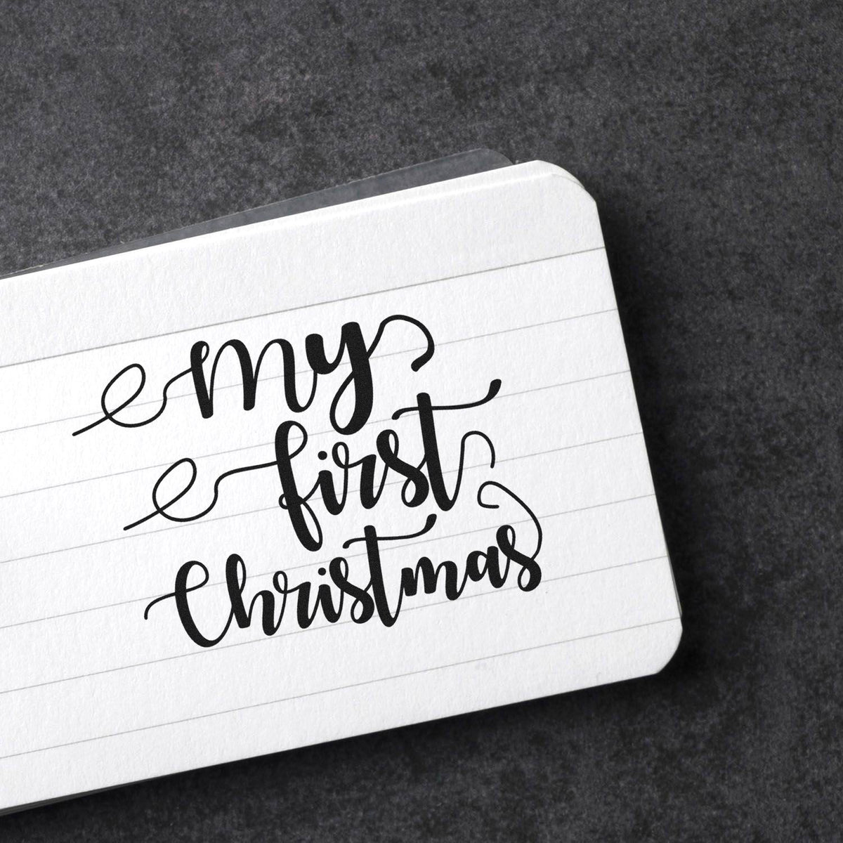 Vintage Pro My First Christmas Script Premium Wooden Stamp imprint stamped in black ink. The words "my first Christmas" appear in flowing script with long curling flourishes.