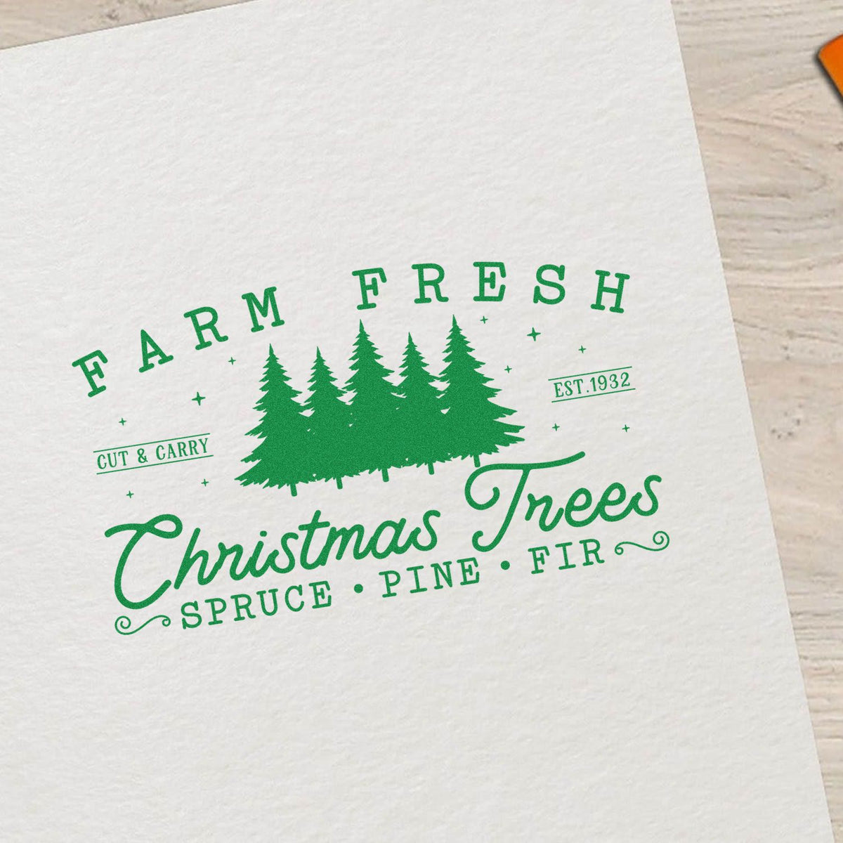 Green farm-fresh Christmas trees rubber stamp design with pine silhouettes, Cut & Carry, and Est. 1932 on white paper.