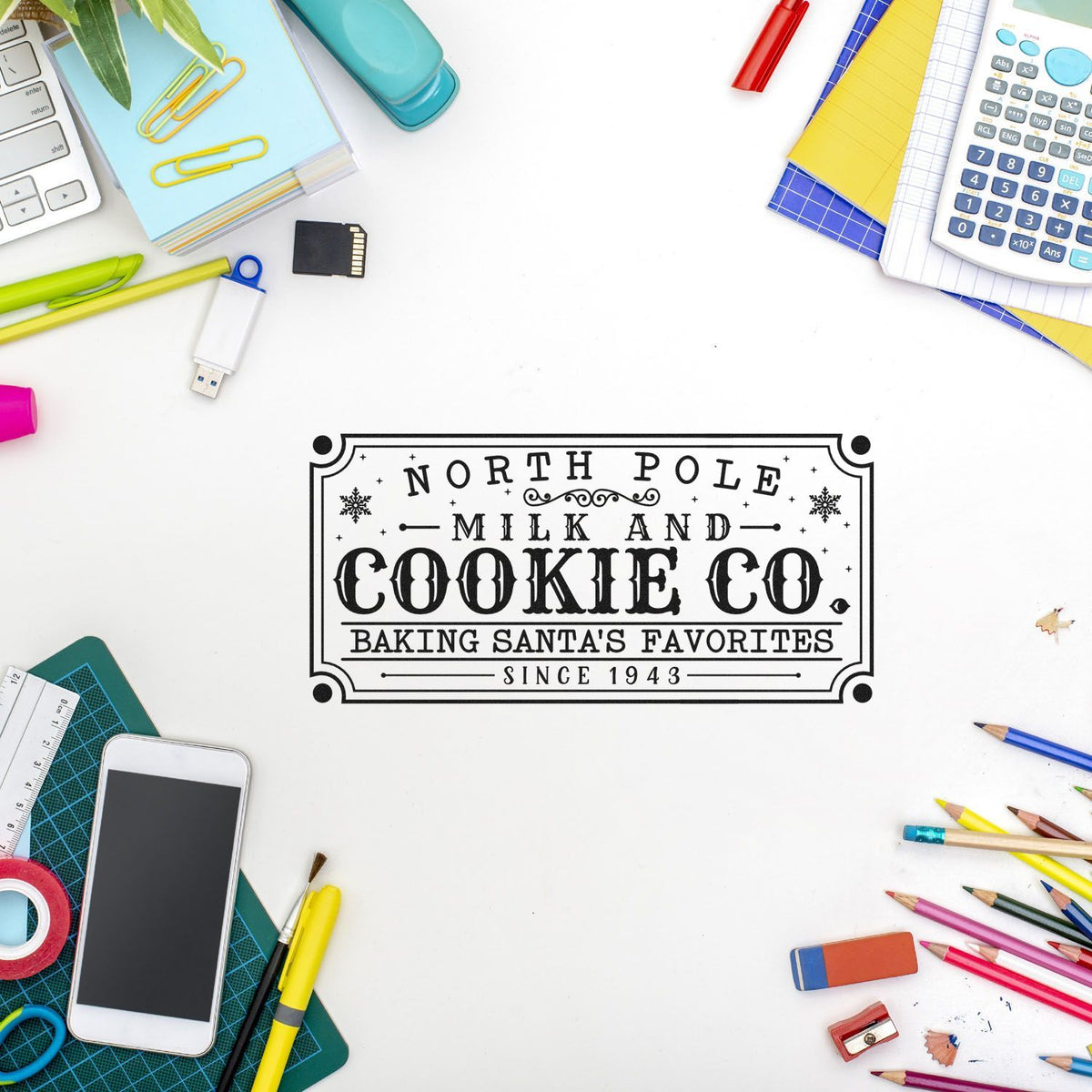Black vintage-style stamp seal reading North Pole Milk and Cookie Co on white desk, framed by colorful stationery.