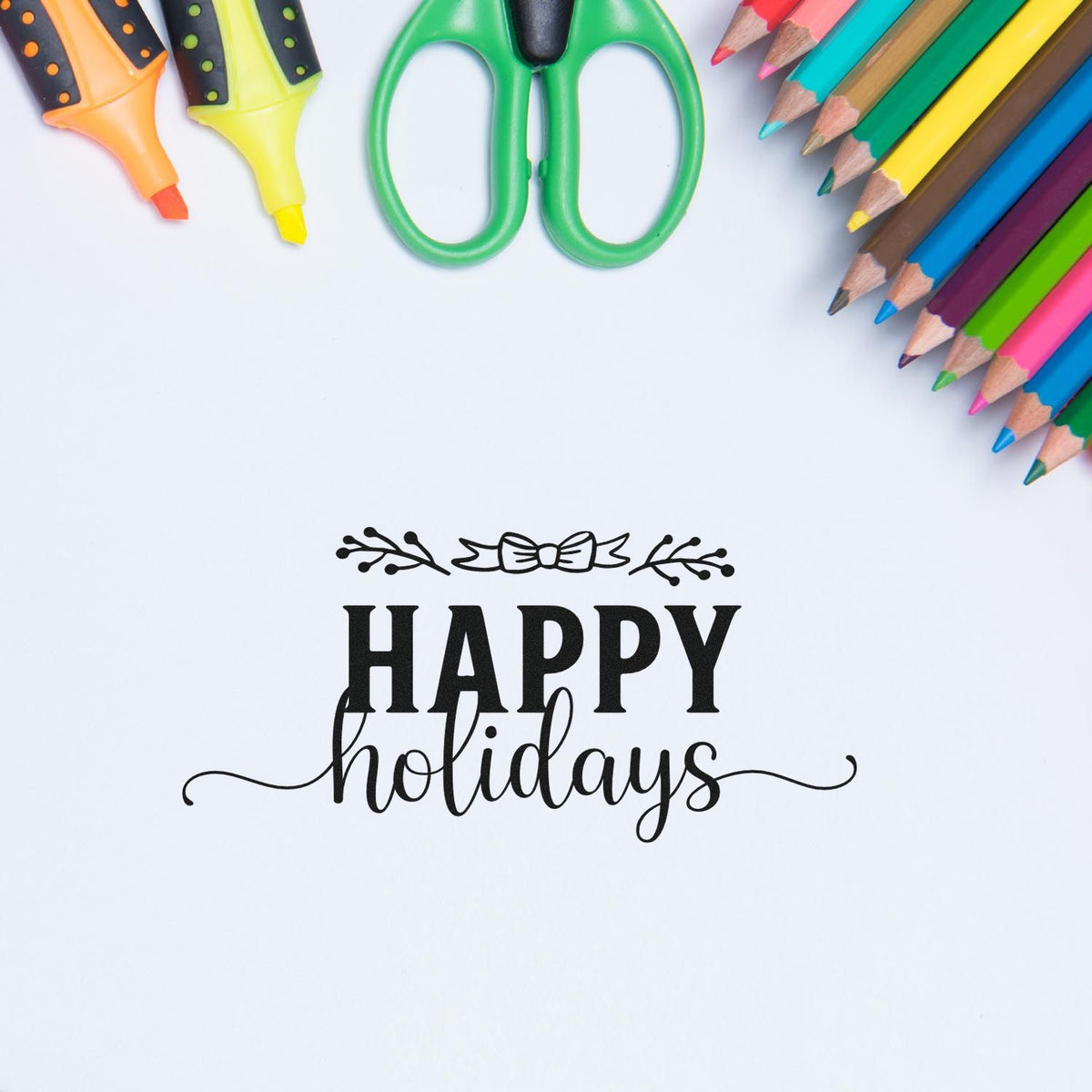 Black Happy Holidays stamp and seal with floral bow design, surrounded by colorful pencils, green scissors, and markers.