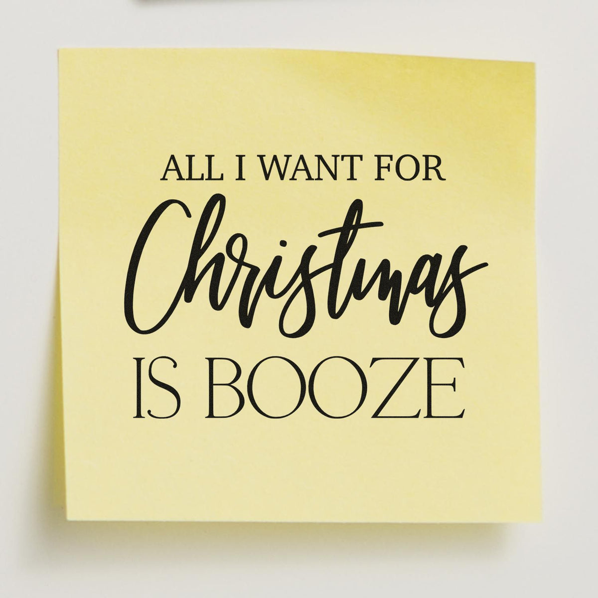 Yellow stamp and seal with black All I Want for Christmas Is Booze text in serif and script fonts.