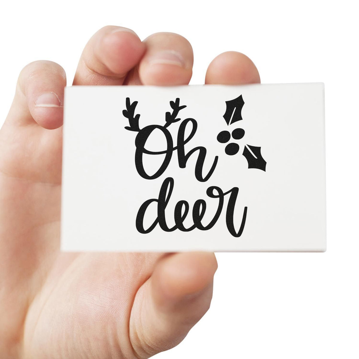 White stamp and seal card with black Oh deer script, deer antlers, and holly accents.
