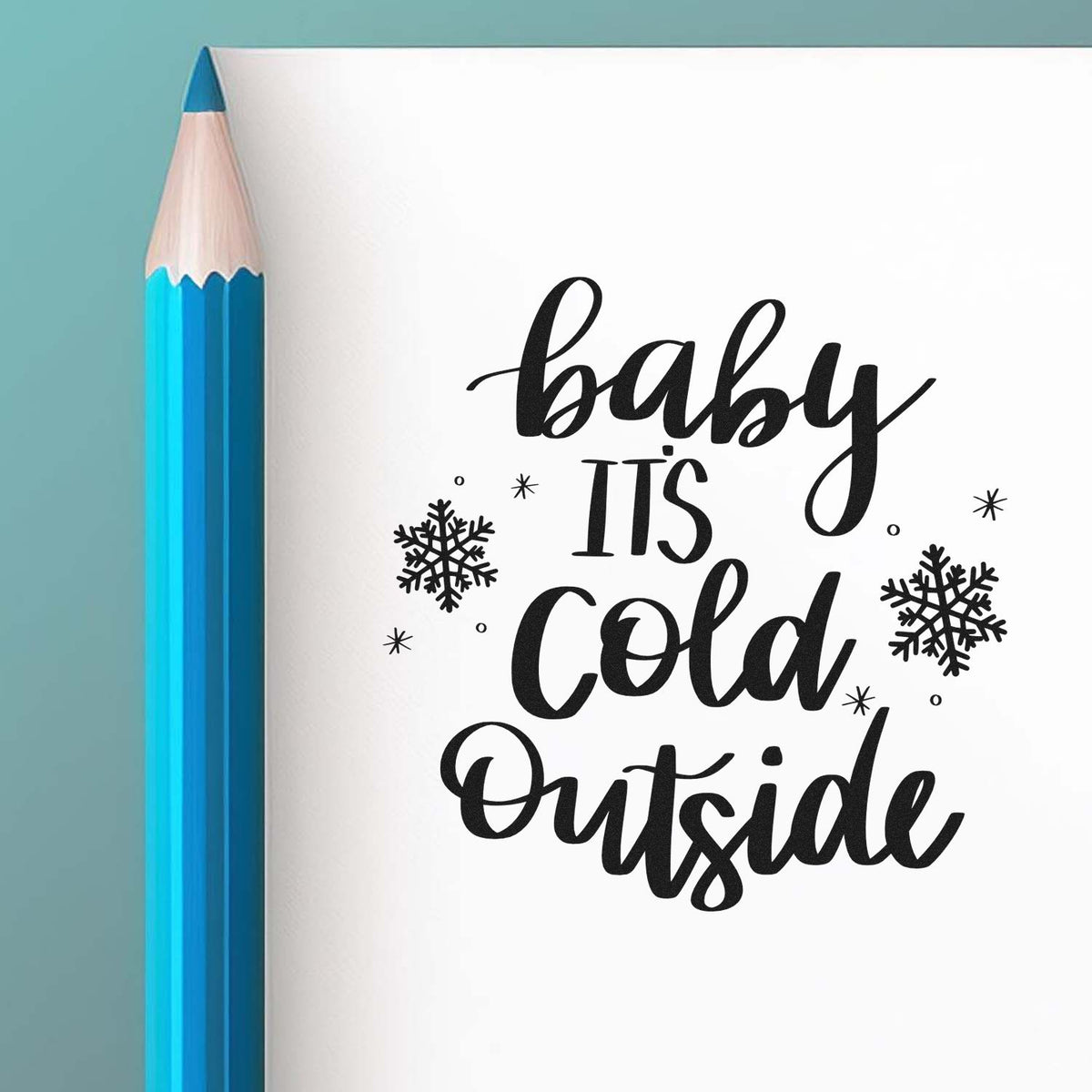 Black baby its cold outside stamp and seal design with snowflakes beside a blue pencil.