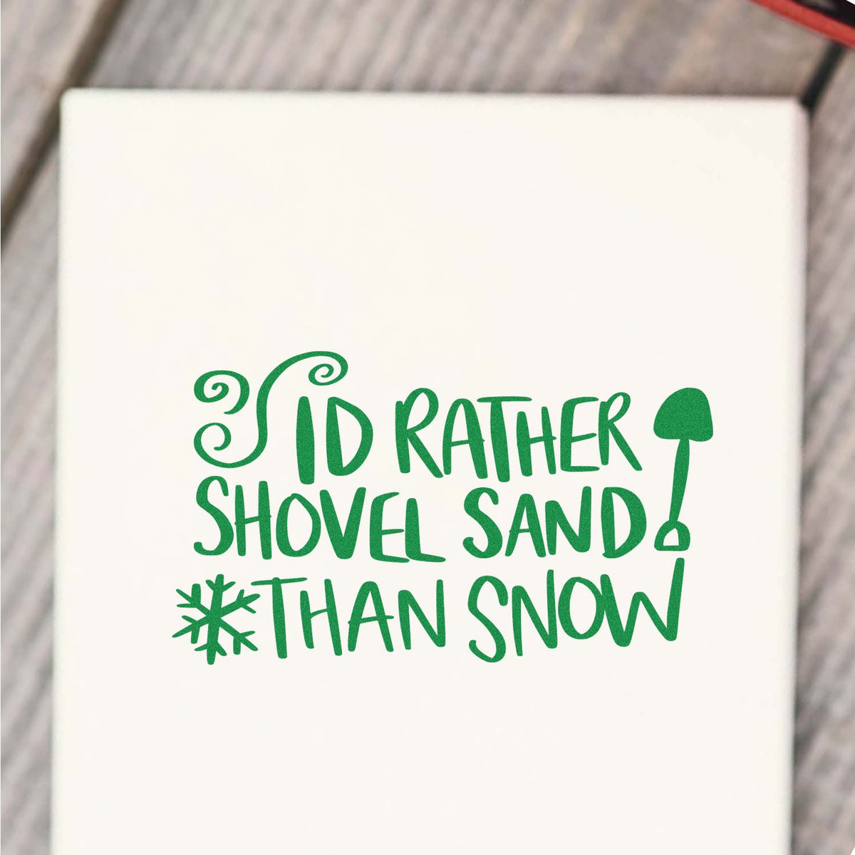 Green stamp and seal design on white reading Id rather shovel sand than snow, with shovel and snowflake icons.
