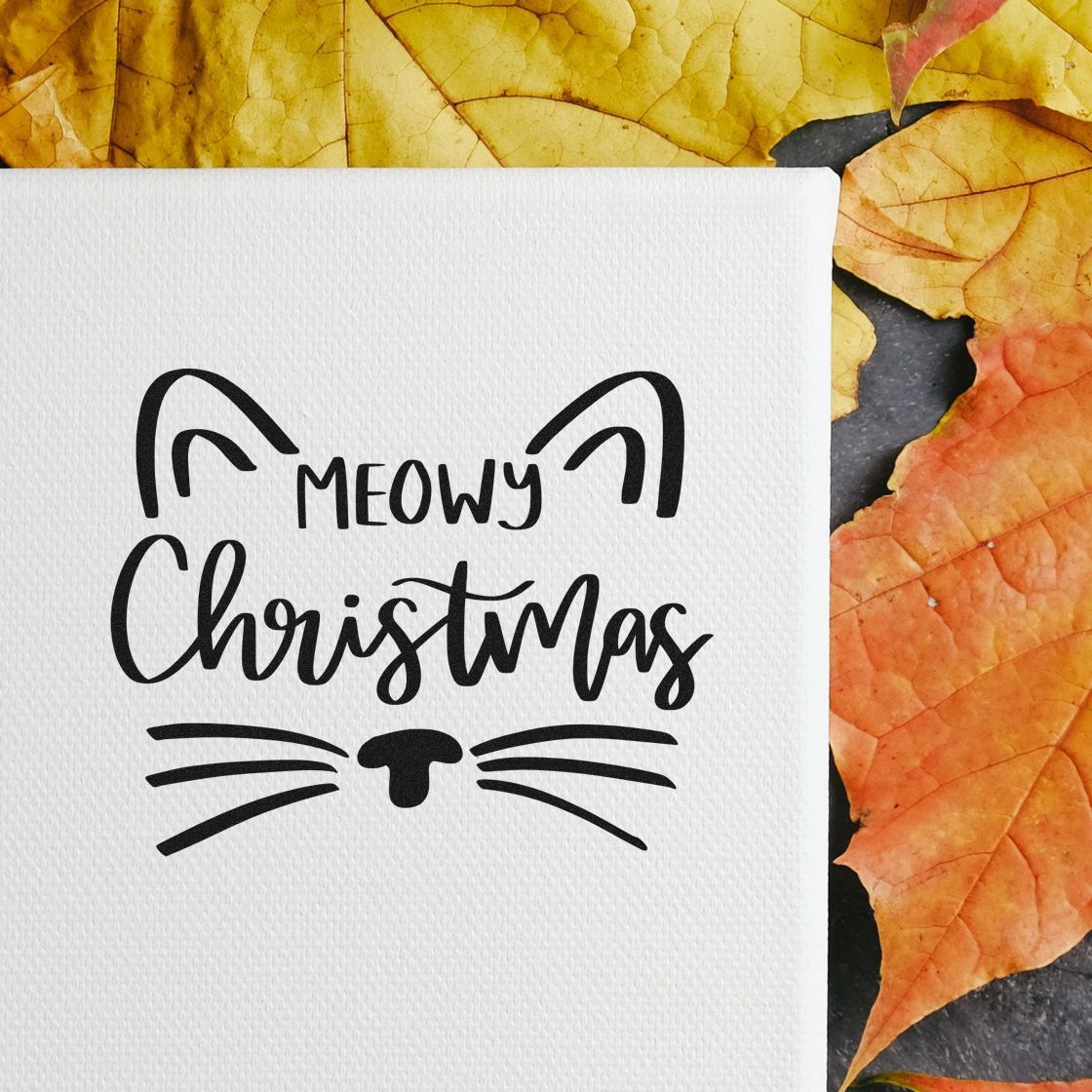 Cat-themed Christmas stamp and seal design in black on white textured paper, framed by yellow and orange autumn leaves.