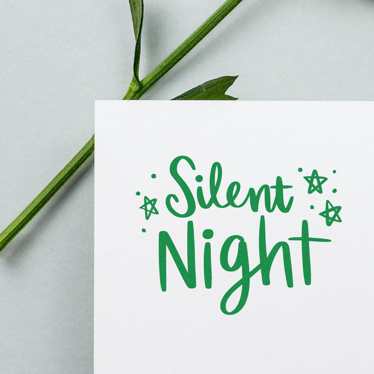 Green Silent Night stamp design with stars on a white card for stamp and seal products.