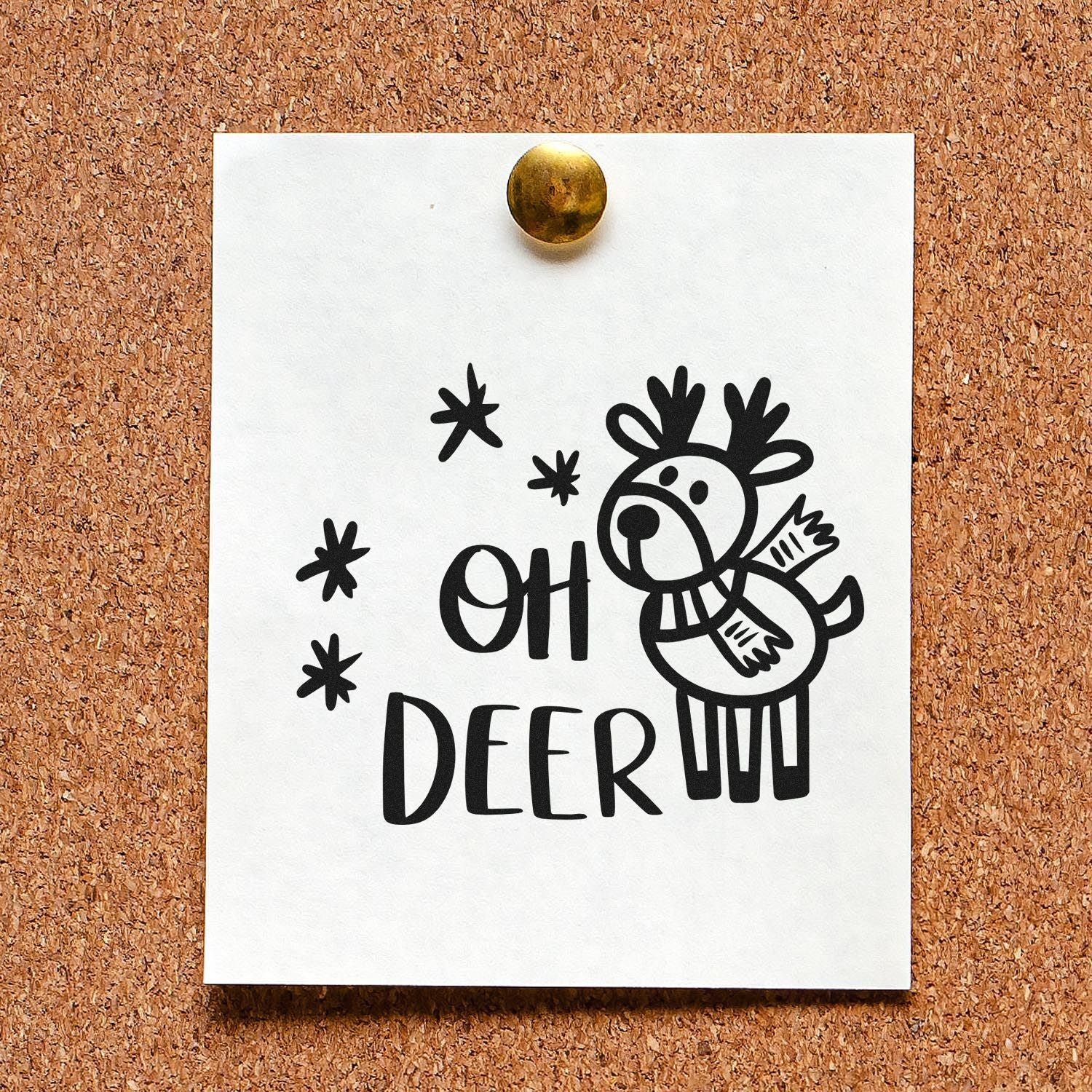 Black rubber stamp/seal design with reindeer and OH DEER, on a white card pinned to a corkboard.