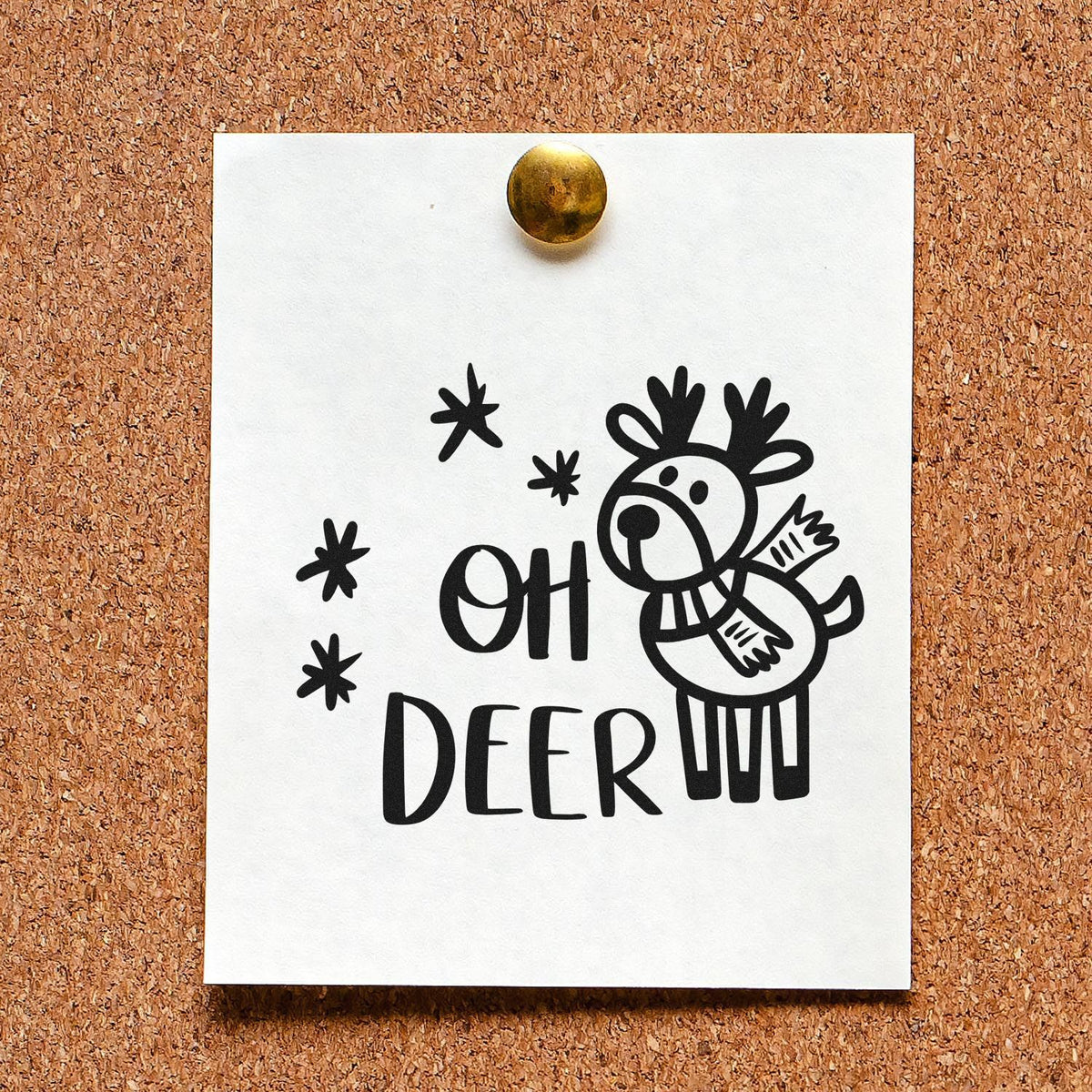 Black Oh Deer reindeer stamp/seal design on white card, pinned with a brass tack on tan corkboard.